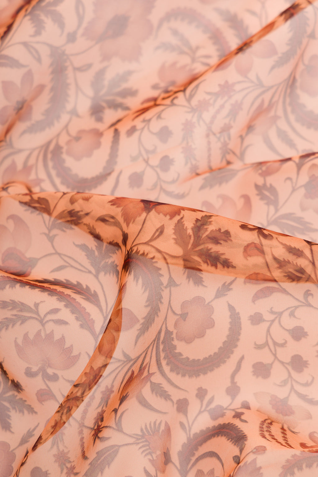 Close up of Orange Dual Tone Organza Silk Saree with Printed design on the body and Embroidery Border.  displaying folds