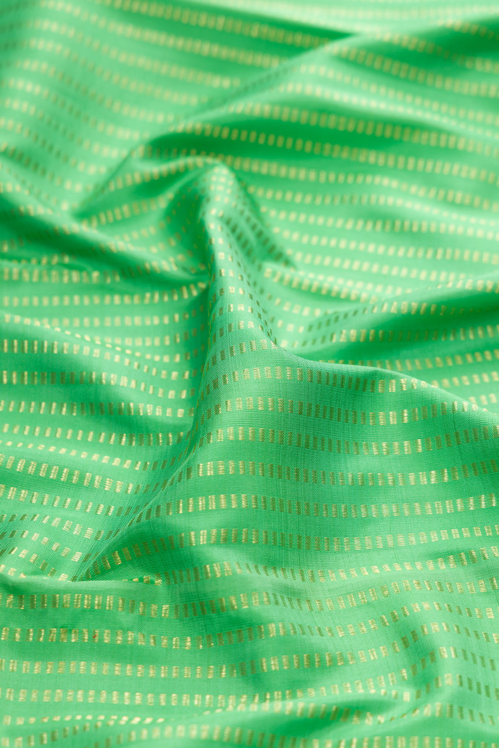 Close up of Green Kanjivaram Silk Saree with Stripes on the body and Thin Zari Line.  displaying folds