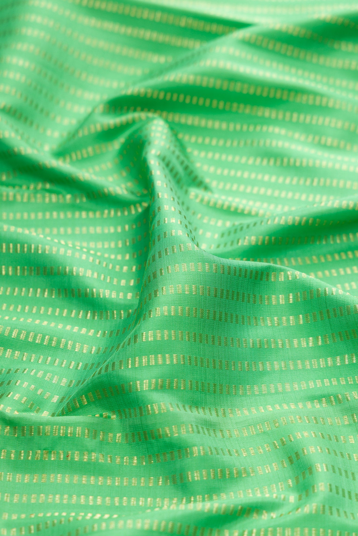 Close up of Green Kanjivaram Silk Saree with Stripes on the body and Thin Zari Line.  displaying folds