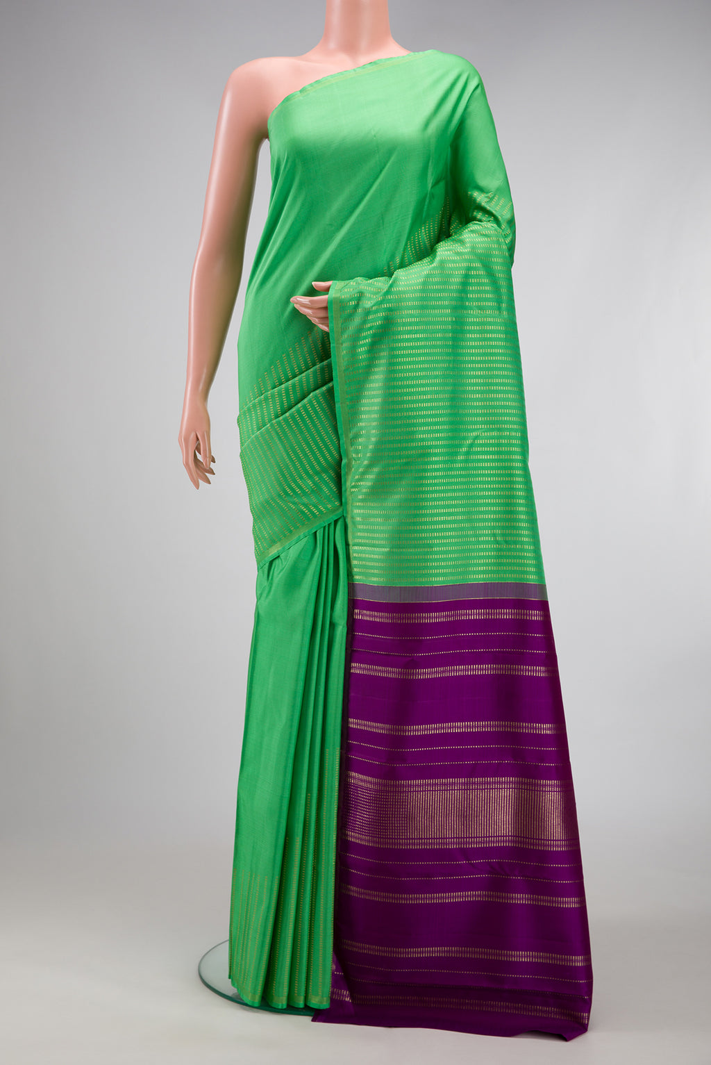 Green Kanjivaram Silk Saree with Stripes on the body and Thin Zari Line.  displayed on a mannequin