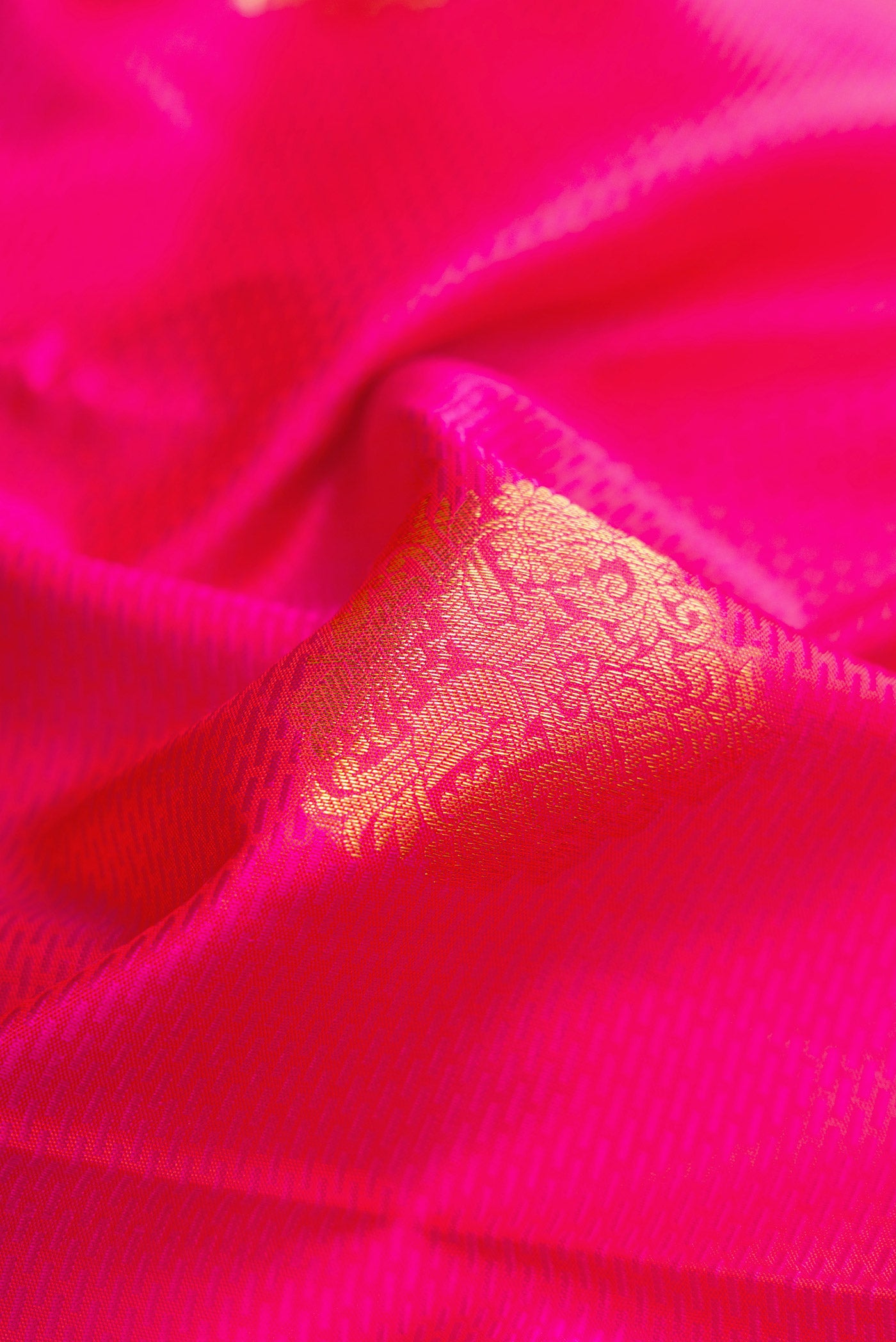 Close up of Pink Dual Tone Kanchipuram Silk Saree with Jacquard With Zari Butta on the body and Zari Border.  displaying folds