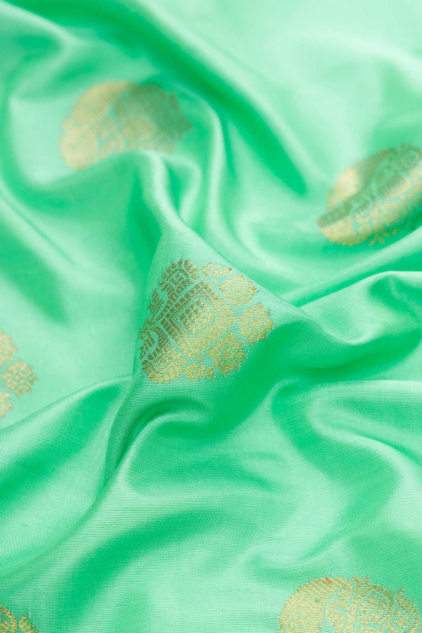 Close up of Sea Green Dual Tone Gadwal Silk Saree with Zari Butta on the body and Zari Border displaying folds
