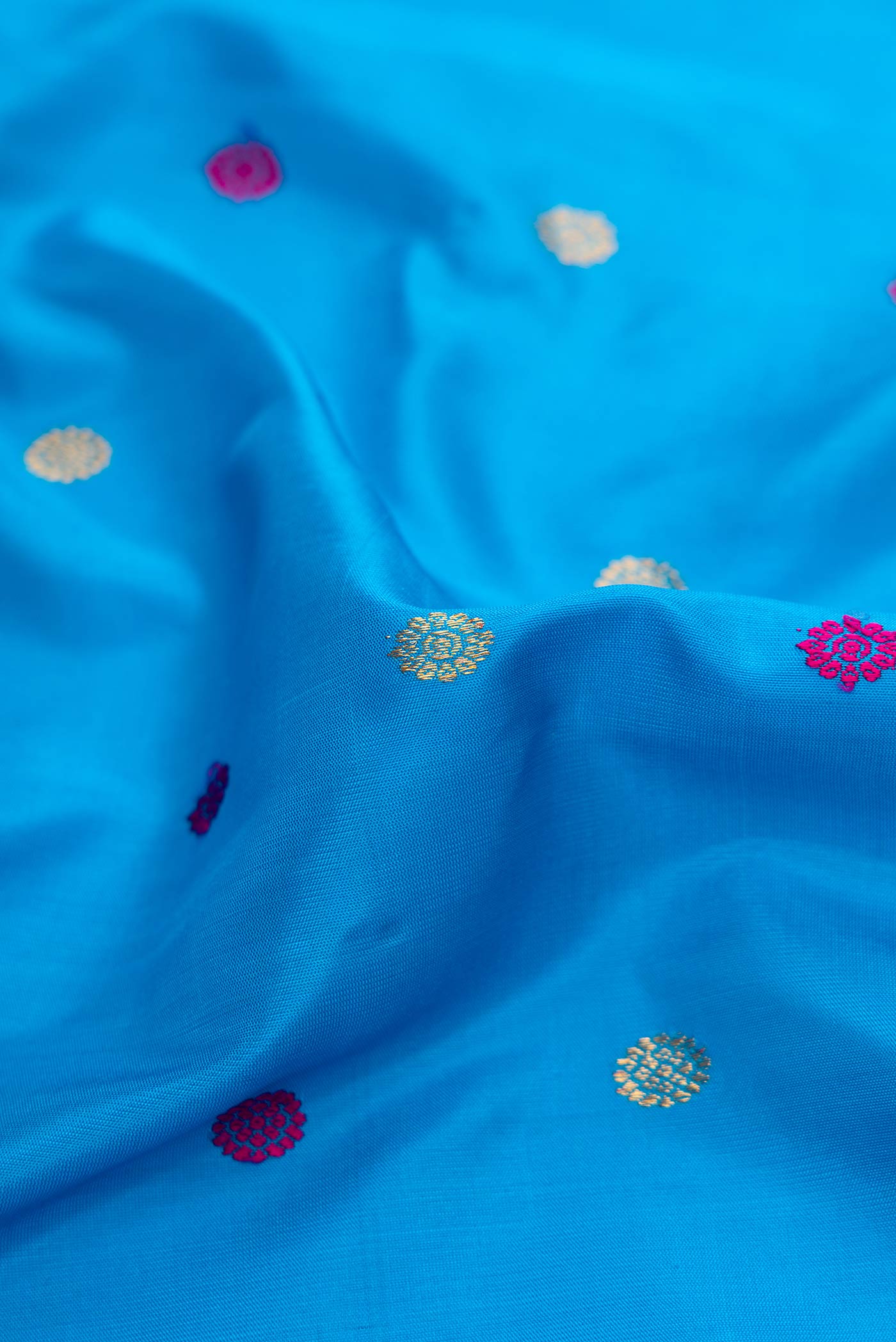 Close up of Sky Blue Dual Tone Gadwal Silk Saree with Zari And Thread Butta on the body and Zari Border displaying folds