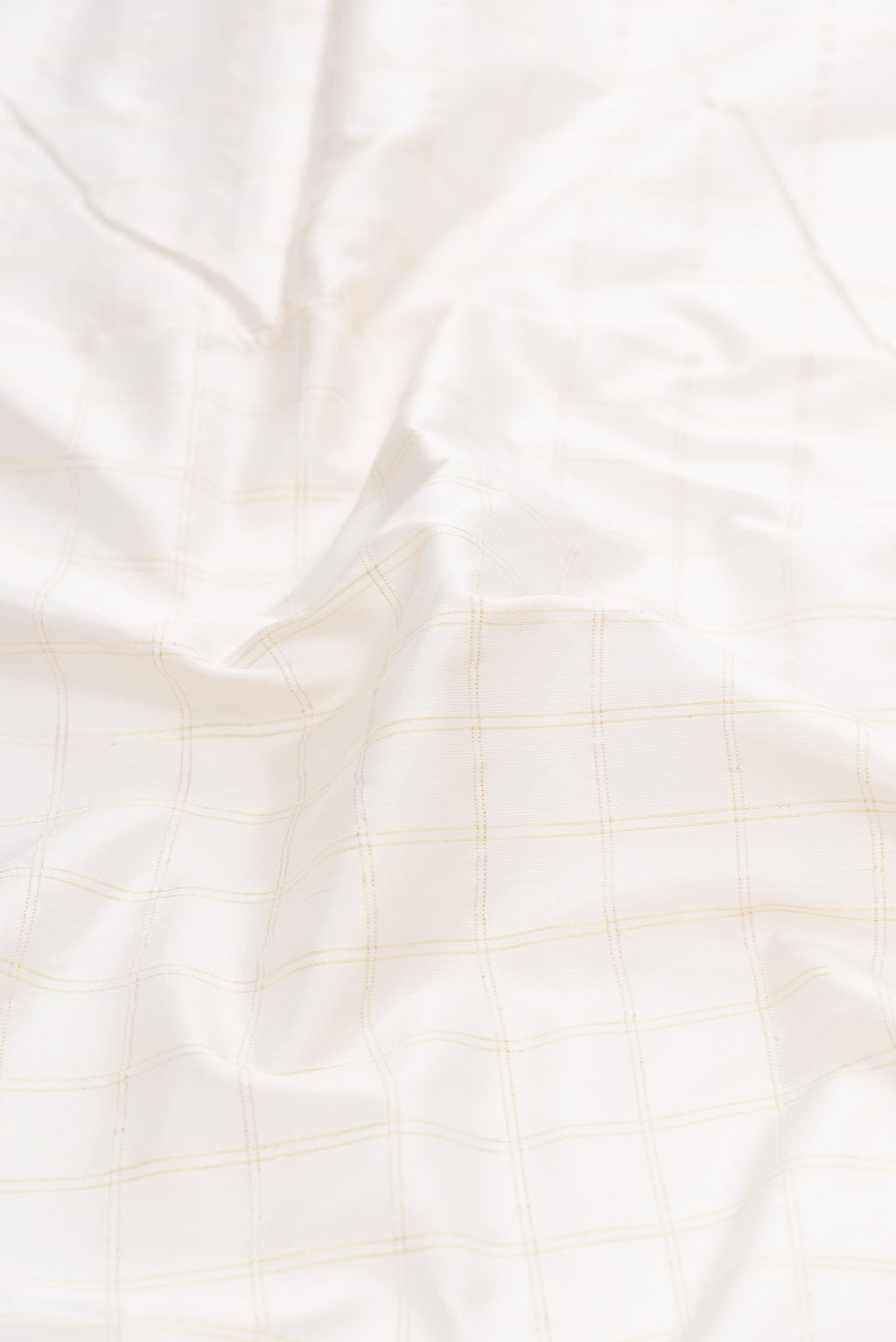 Close up of White Dual Tone Paithani Silk Saree with Checked design on the body and Paithani Border.  displaying folds