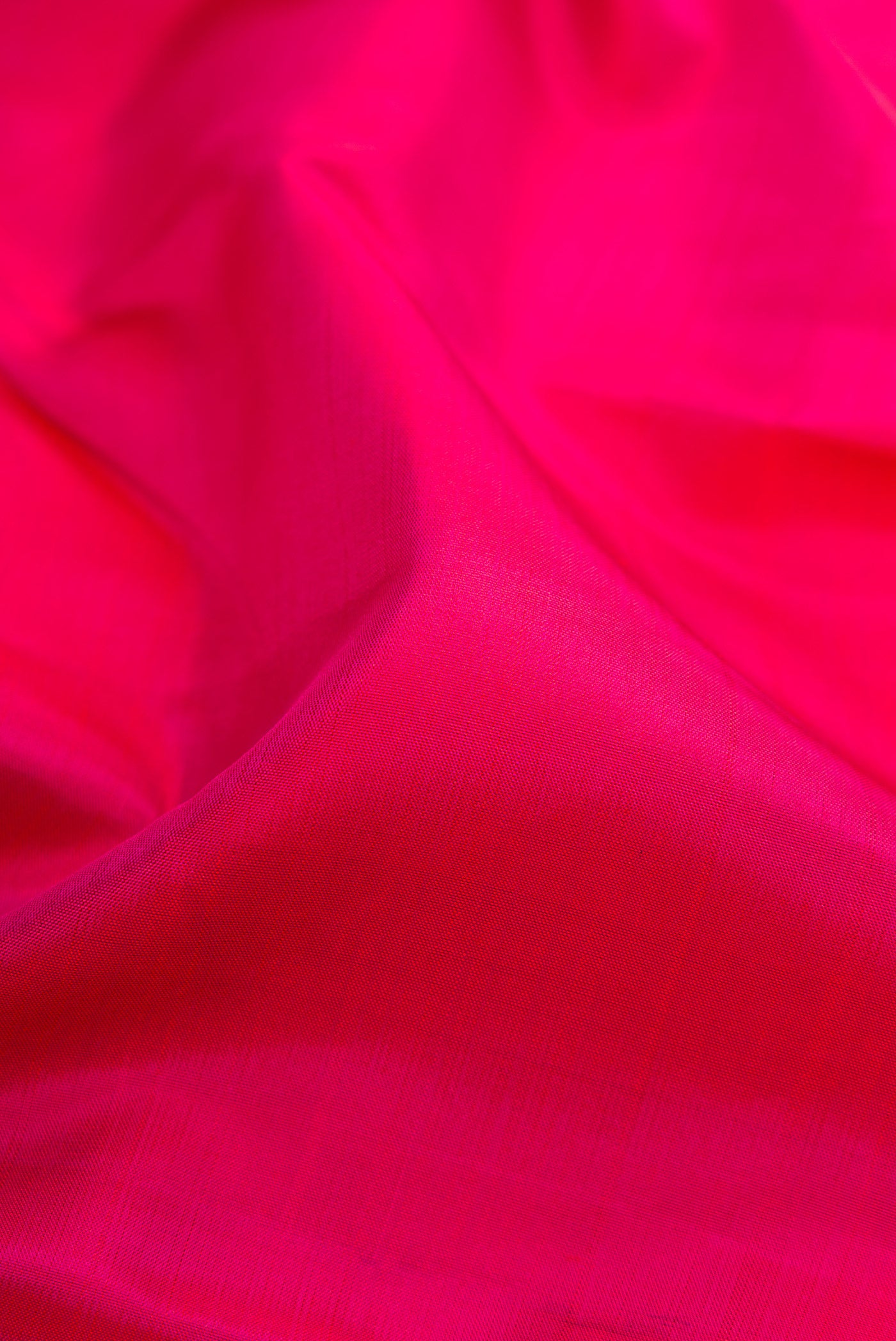 Close up of Pink Dual Tone Kanchipuram Silk Saree with Plain Body and Fancy Border.  displaying folds