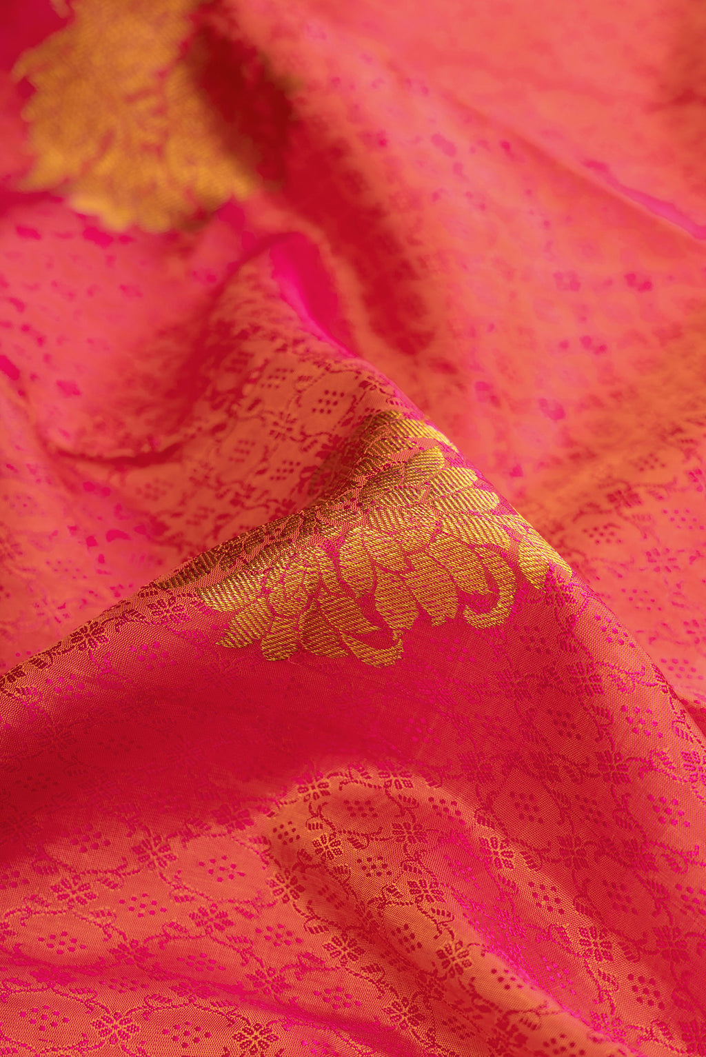 Close up of Coral Dual Tone Kanchipuram Silk Saree with Jacquard With Zari Butta on the body and Zari Border.  displaying folds
