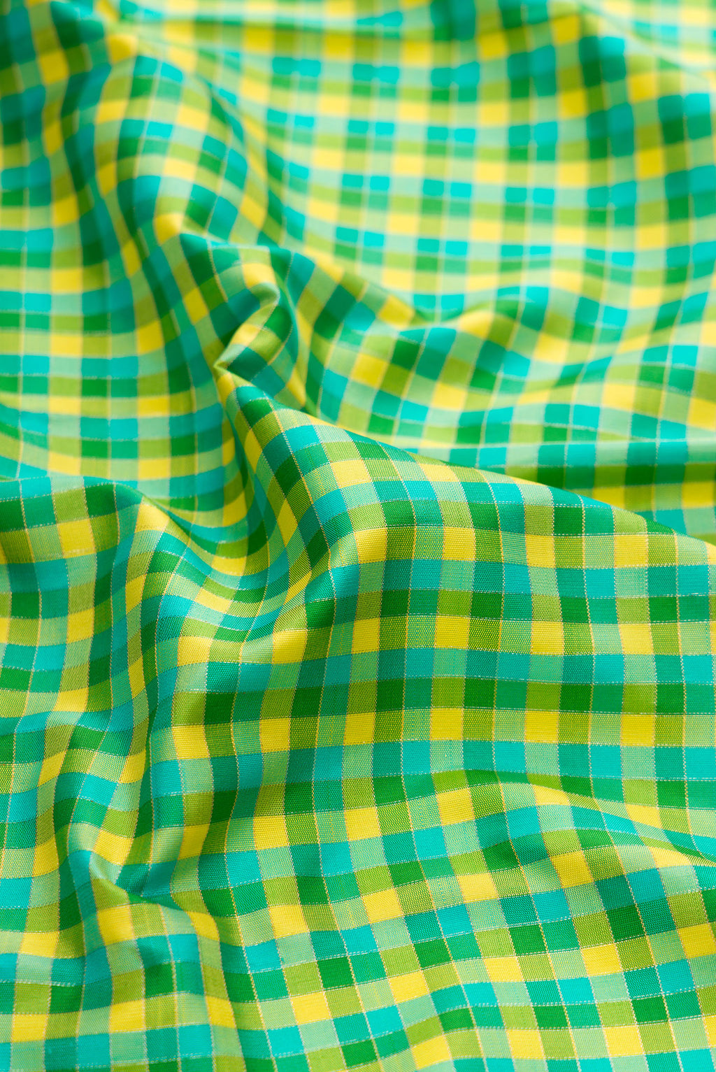 Close up of Green Dual Tone Kanjivaram Silk Saree with Checked design on the body and Temple Border.  displaying folds