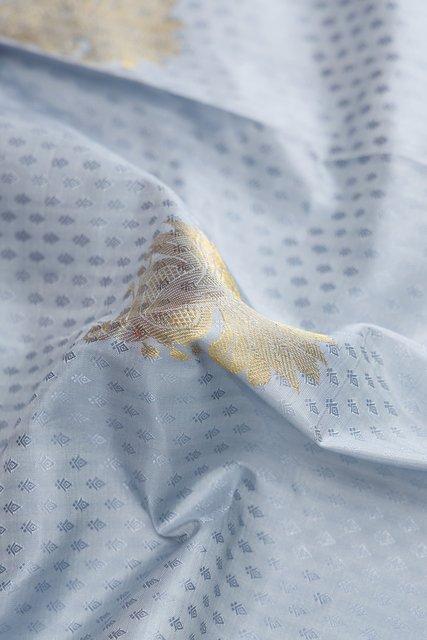 Close up of Pure Silk Pure Zari Grey Dual Tone Kanjivaram Saree with Jacquard With Zari Butta on the body and Zari Border.  displaying folds