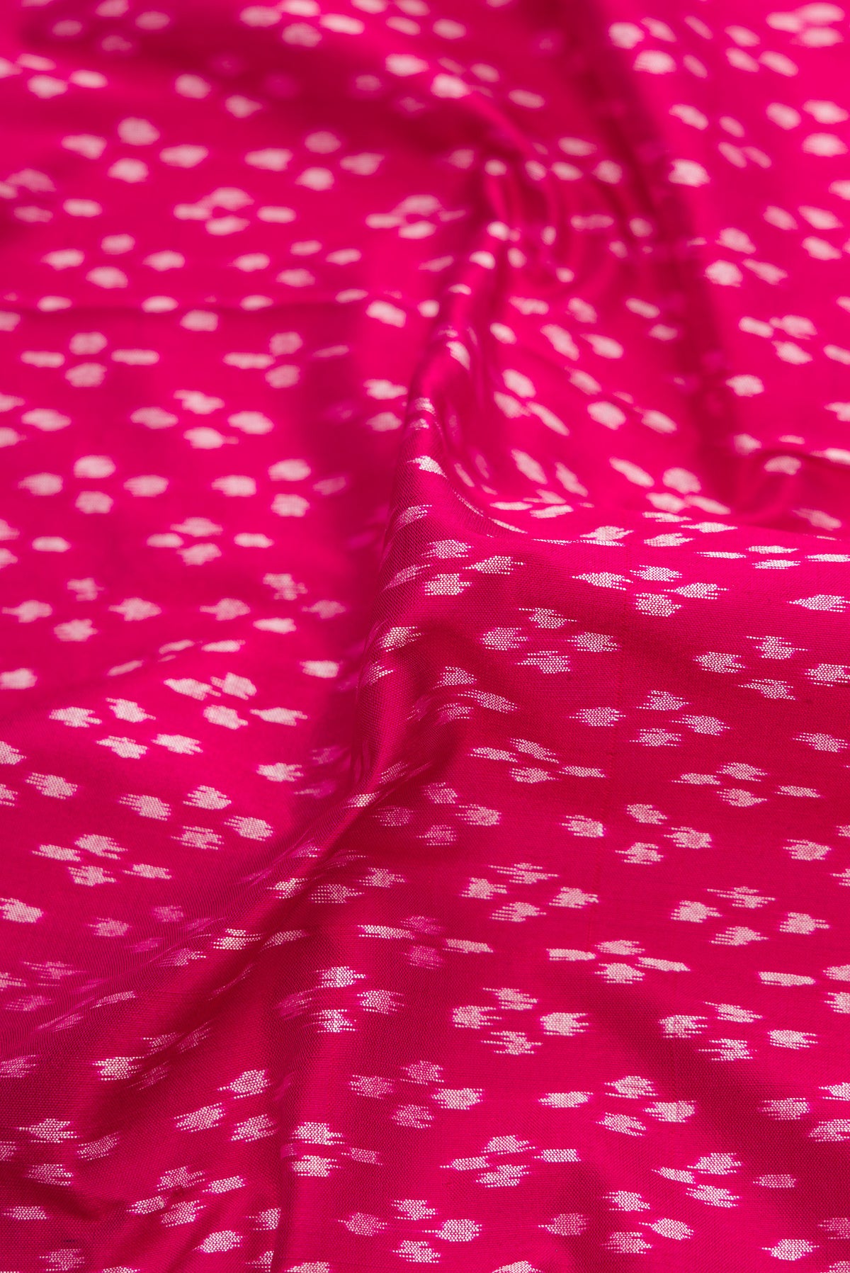 Close up of Pink Dual Tone Double Ikat Saree with Ikat Print on the body and Thread Border.  displaying folds