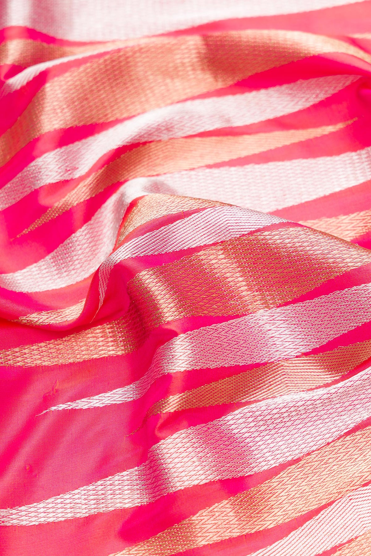 Close up of Coral Dual Tone Banarasi Silk Saree with Zari Butta on the body and Zari Border.  displaying folds
