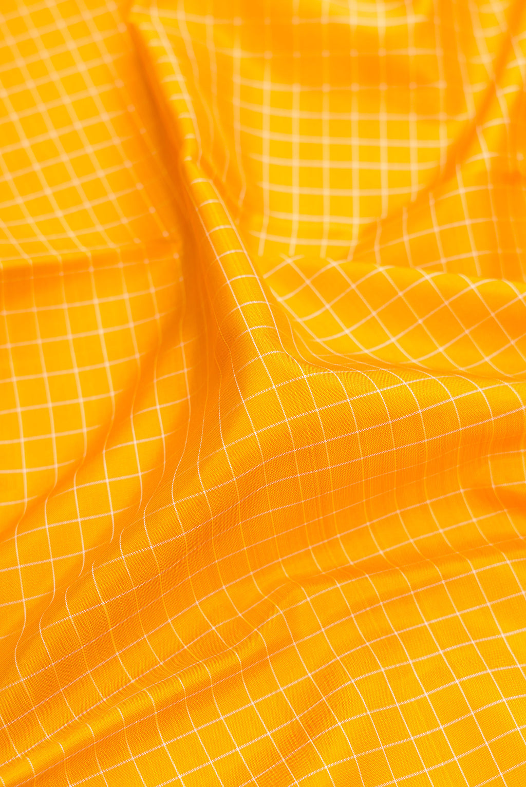 Close up of Pure Silk Pure Zari Yellow Kanjivaram Saree with Checked design on the body and Temple Border.  displaying folds