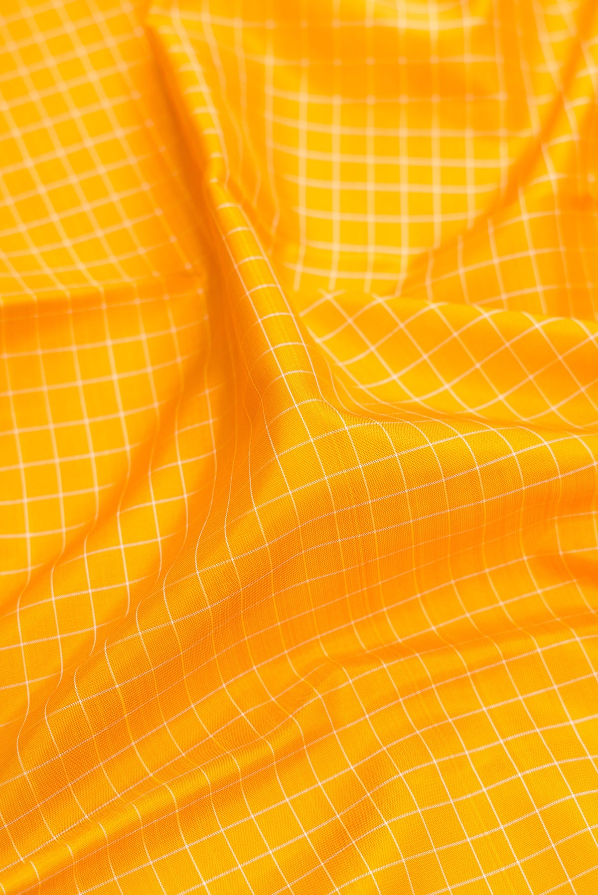 Close up of Pure Silk Pure Zari Yellow Kanjivaram Saree with Checked design on the body and Temple Border.  displaying folds
