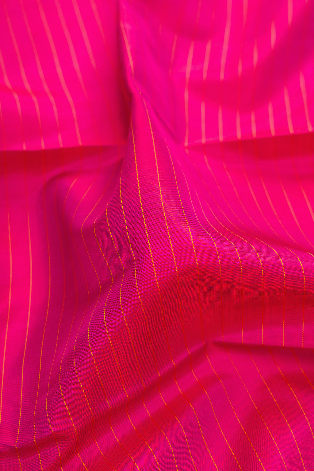 Close up of Pure Silk Pure Zari Dark Pink Kanjivaram Saree with Stripes on the body and Fancy Border.  displaying folds