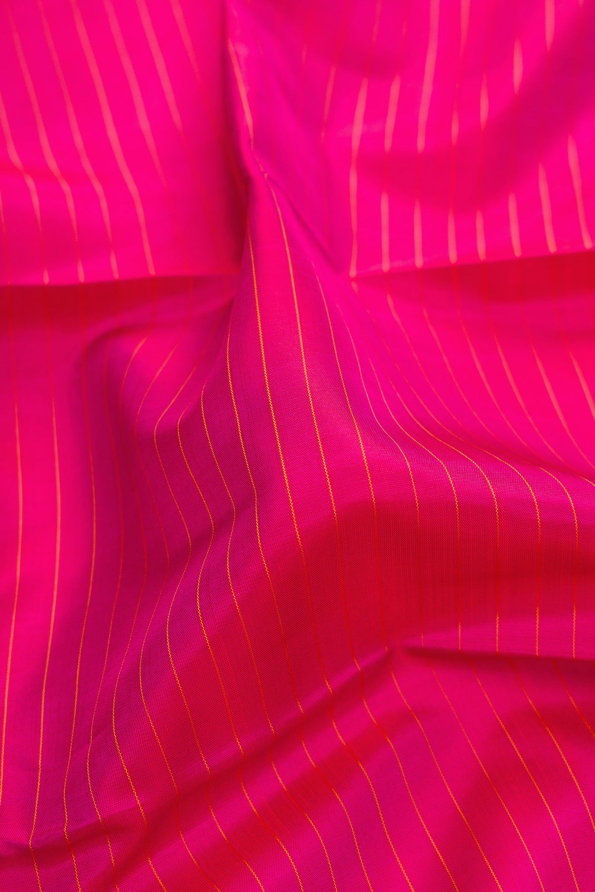Close up of Pure Silk Pure Zari Dark Pink Kanjivaram Saree with Stripes on the body and Fancy Border.  displaying folds
