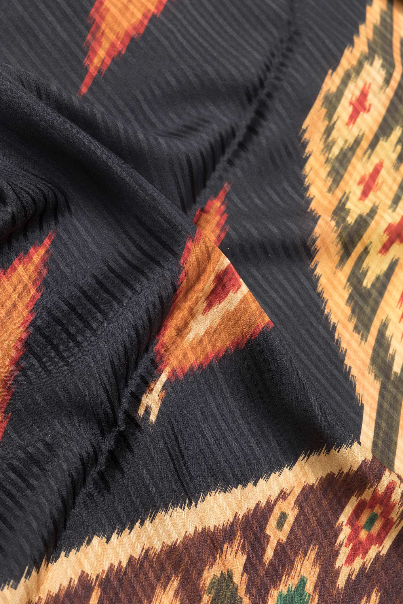 Close up of Black Dual Tone Mysore Crepe Saree with Printed design on the body and Zari Border.  displaying folds