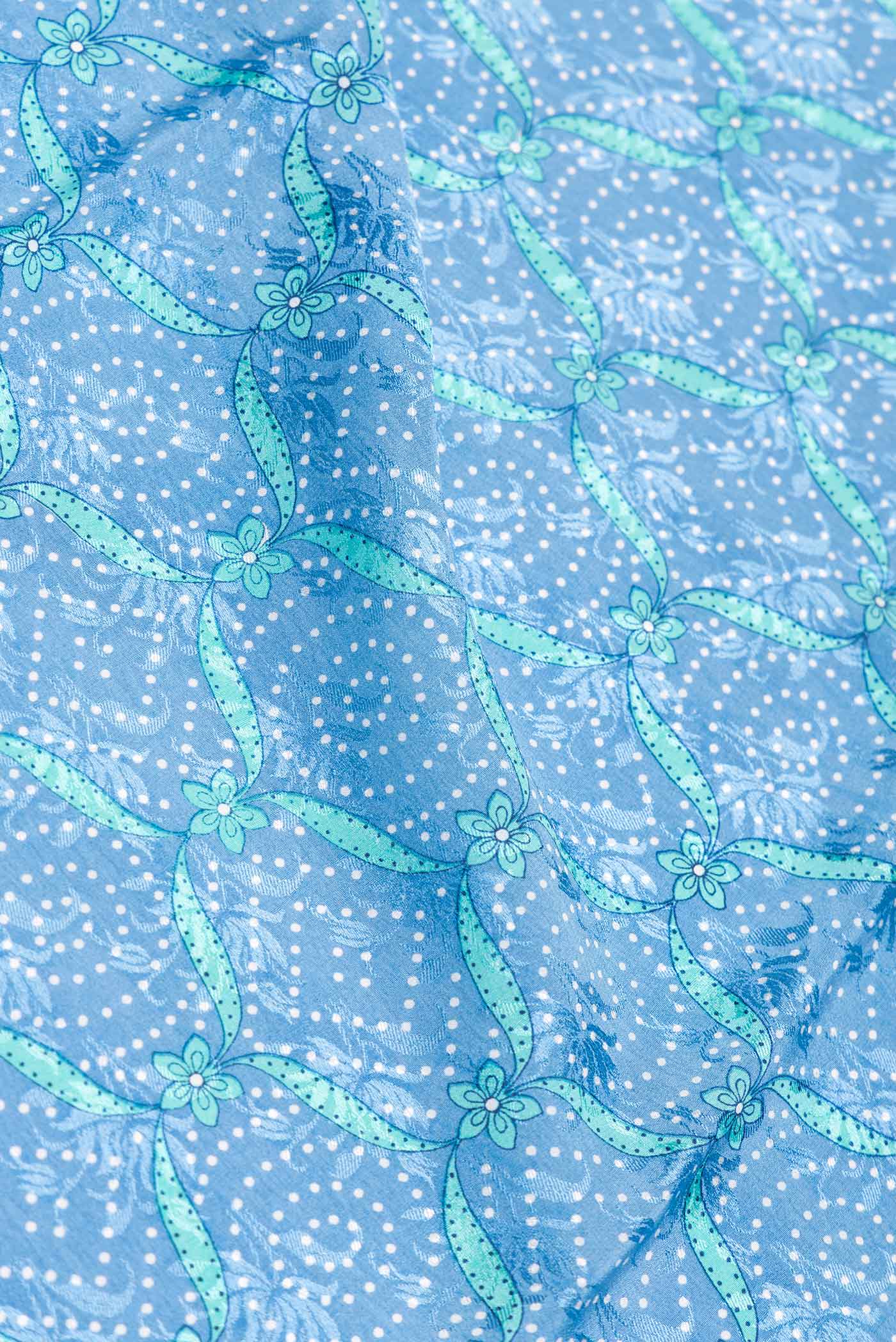 Close up of Sky Blue Dual Tone Mysore Crepe Saree with Printed design on the body and Zari Border.  displaying folds