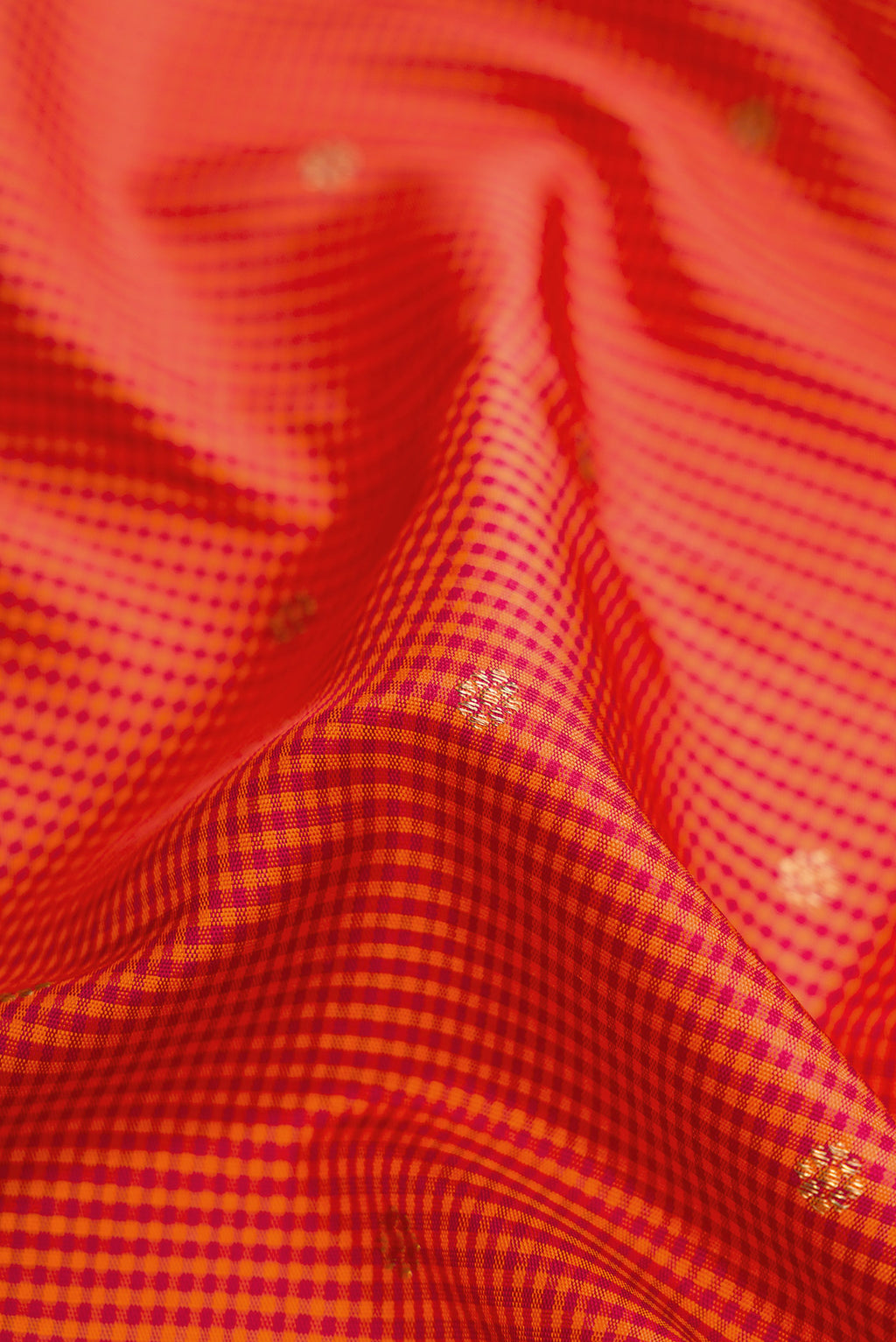 Close up of Pure Silk Pure Zari Orange Dual Tone Kanchipuram Saree with Checked design on the body and Zari Border.  displaying folds