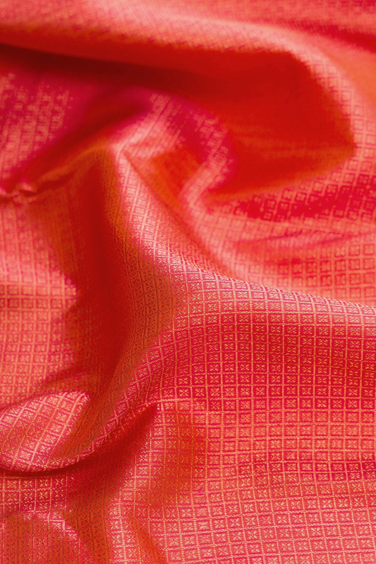 Close up of Brick Orange Dual Tone Kanjivaram Silk Saree with Zari Brocade on the body and Fancy Border.  displaying folds