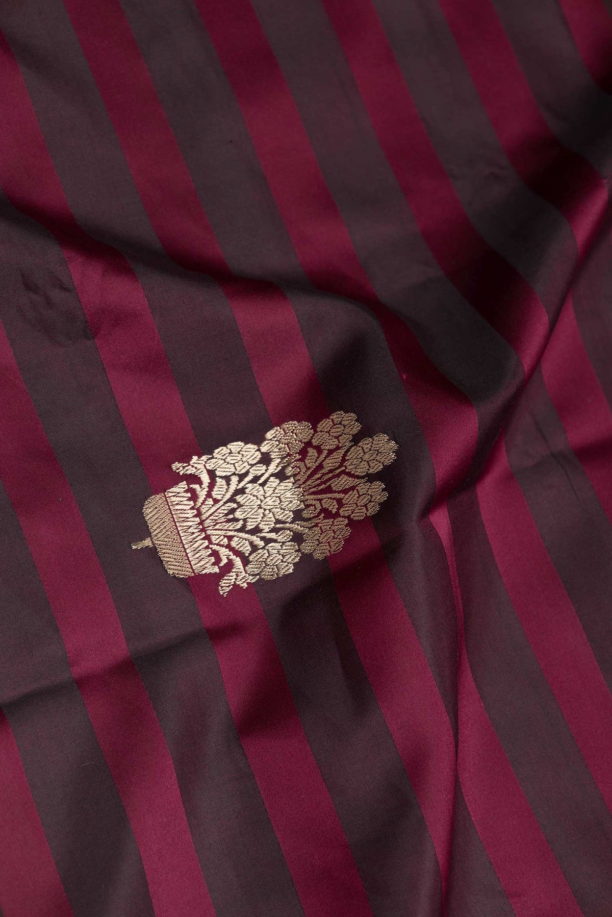 Close up of Maroon Dual Tone Banarasi Saree with Zari Butta on the body and Zari Border displaying folds