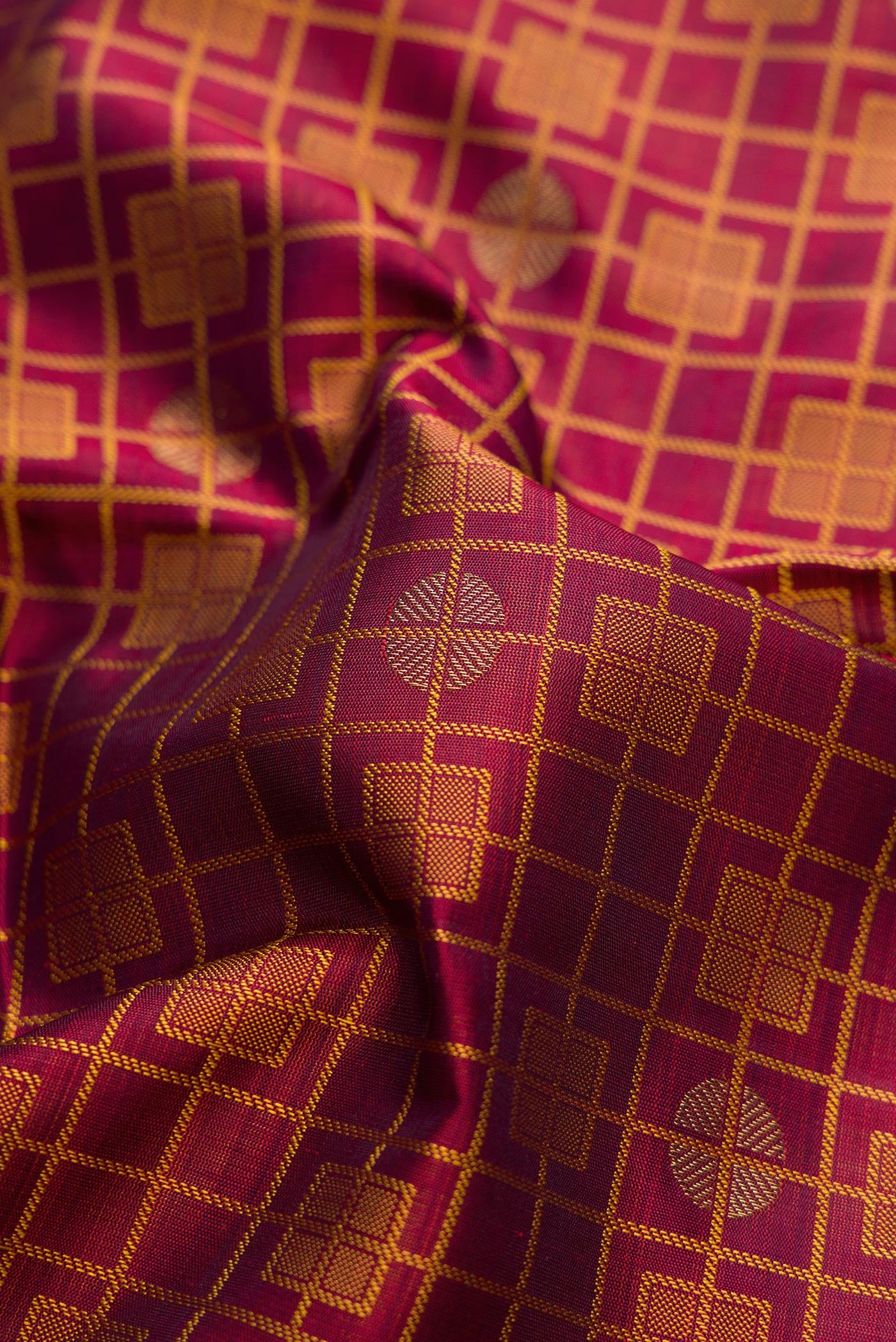 Close up of Maroon Dual Tone Kanchipuram Silk Saree with Jacquard design on the body and Zari Border.  displaying folds