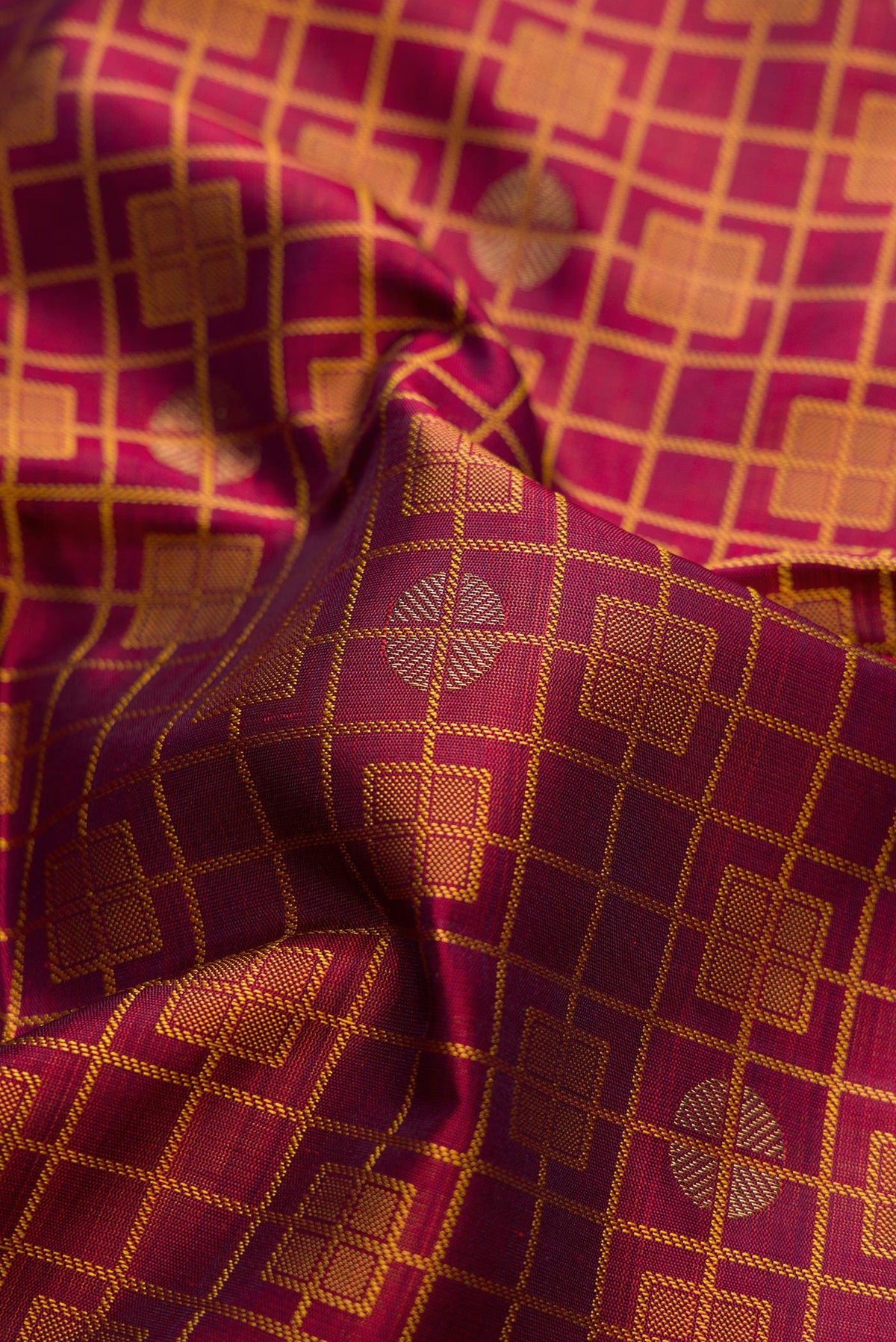Close up of Maroon Dual Tone Kanchipuram Silk Saree with Jacquard design on the body and Zari Border.  displaying folds