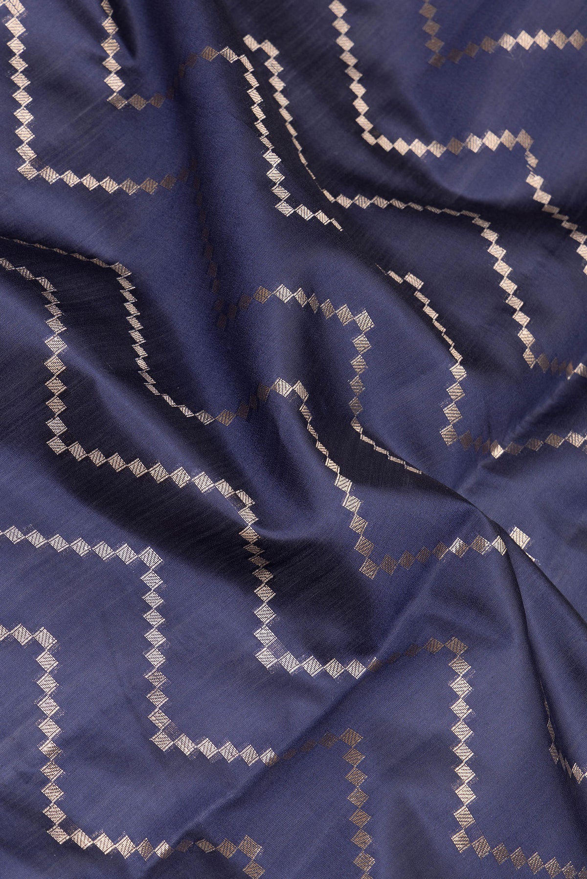 Close up of Navy Blue Dual Tone Tussar Silk Saree with Zari Brocade on the body and Zari Border.  displaying folds