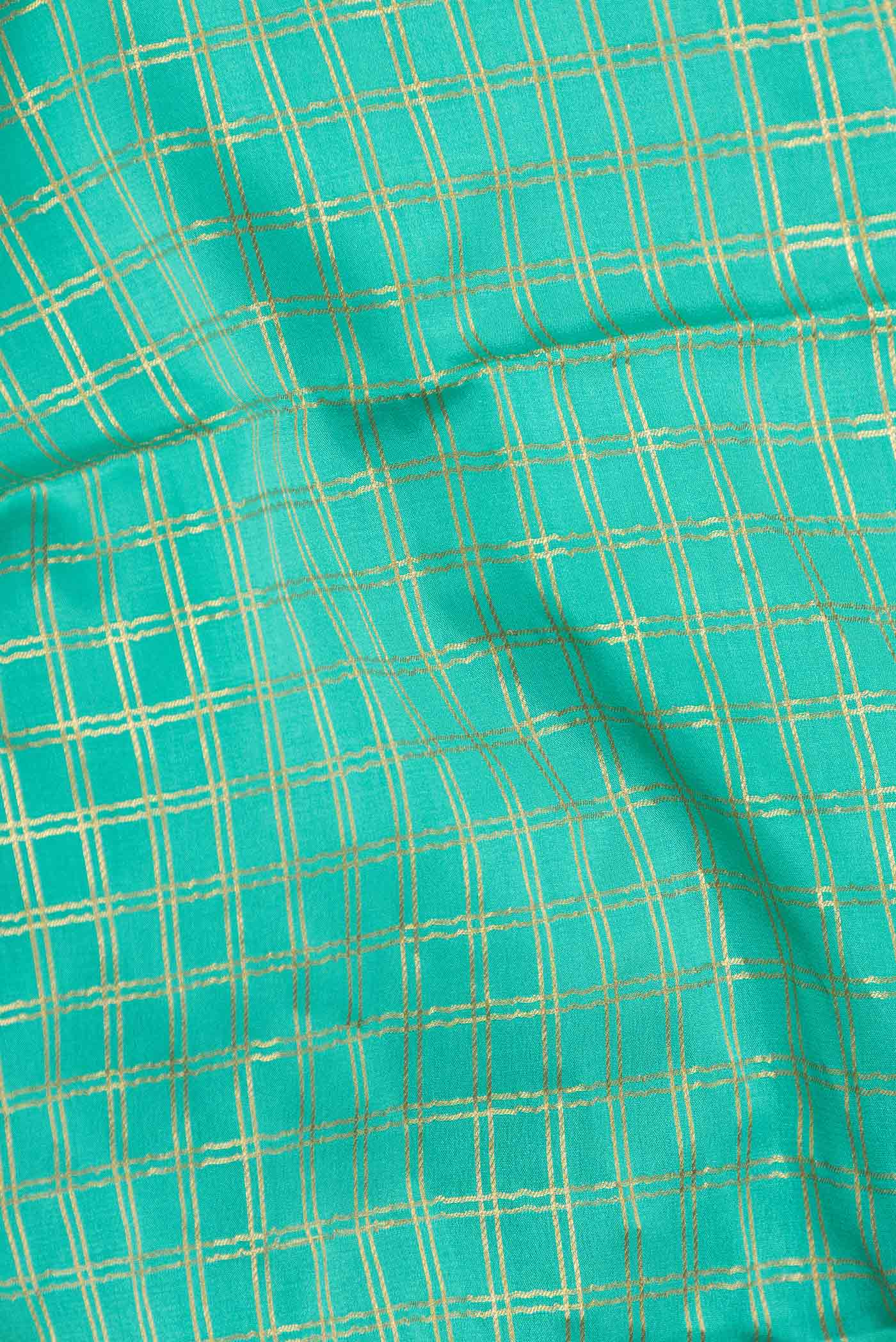 Close up of Sea Green Dual Tone Mysore Crepe Saree with Checked design on the body and Zari Border displaying folds