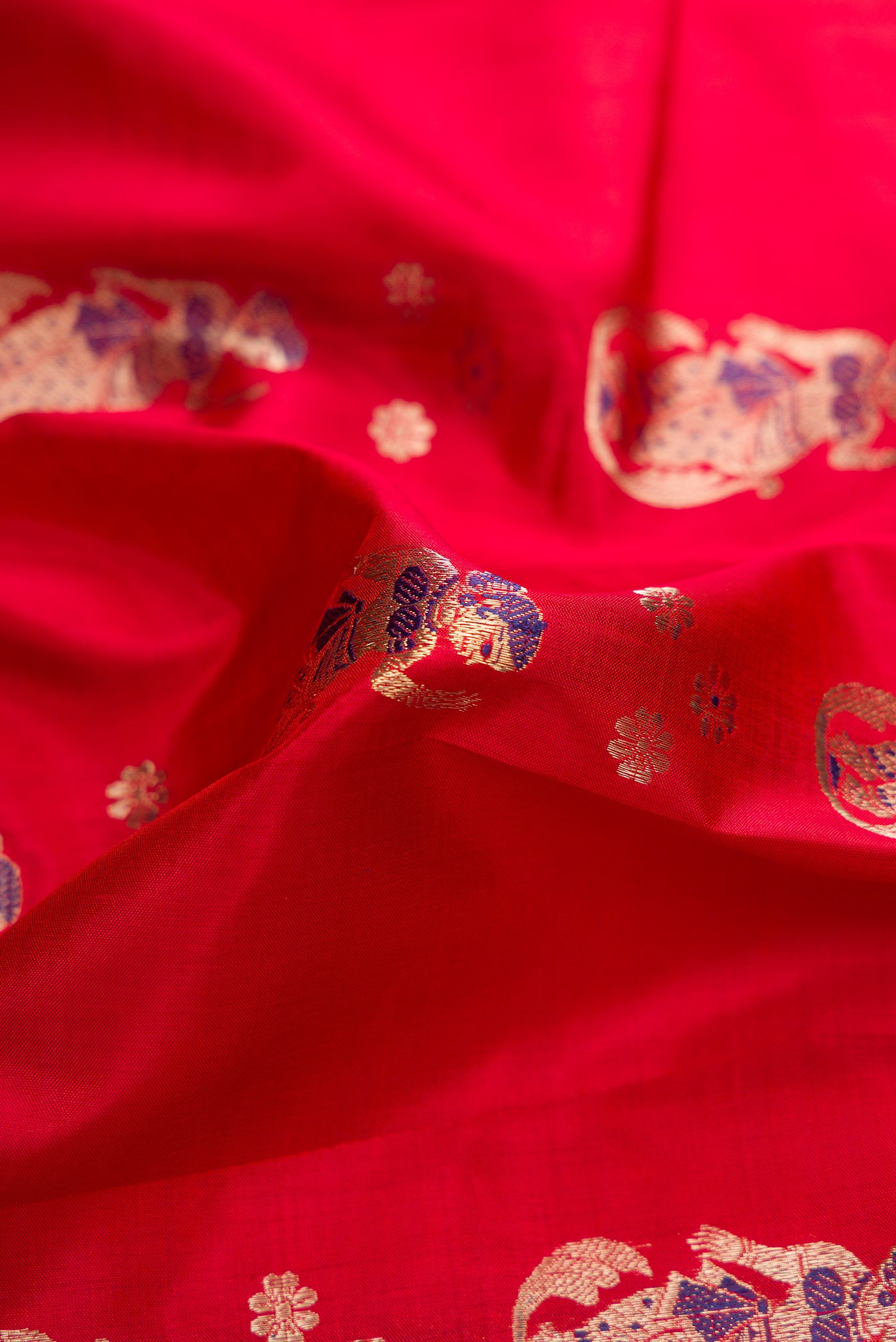 Close up of Dark Mauve Dual Tone Baluchari Silk Saree with Zari And Thread Butta on the body and Fancy Border.  displaying folds