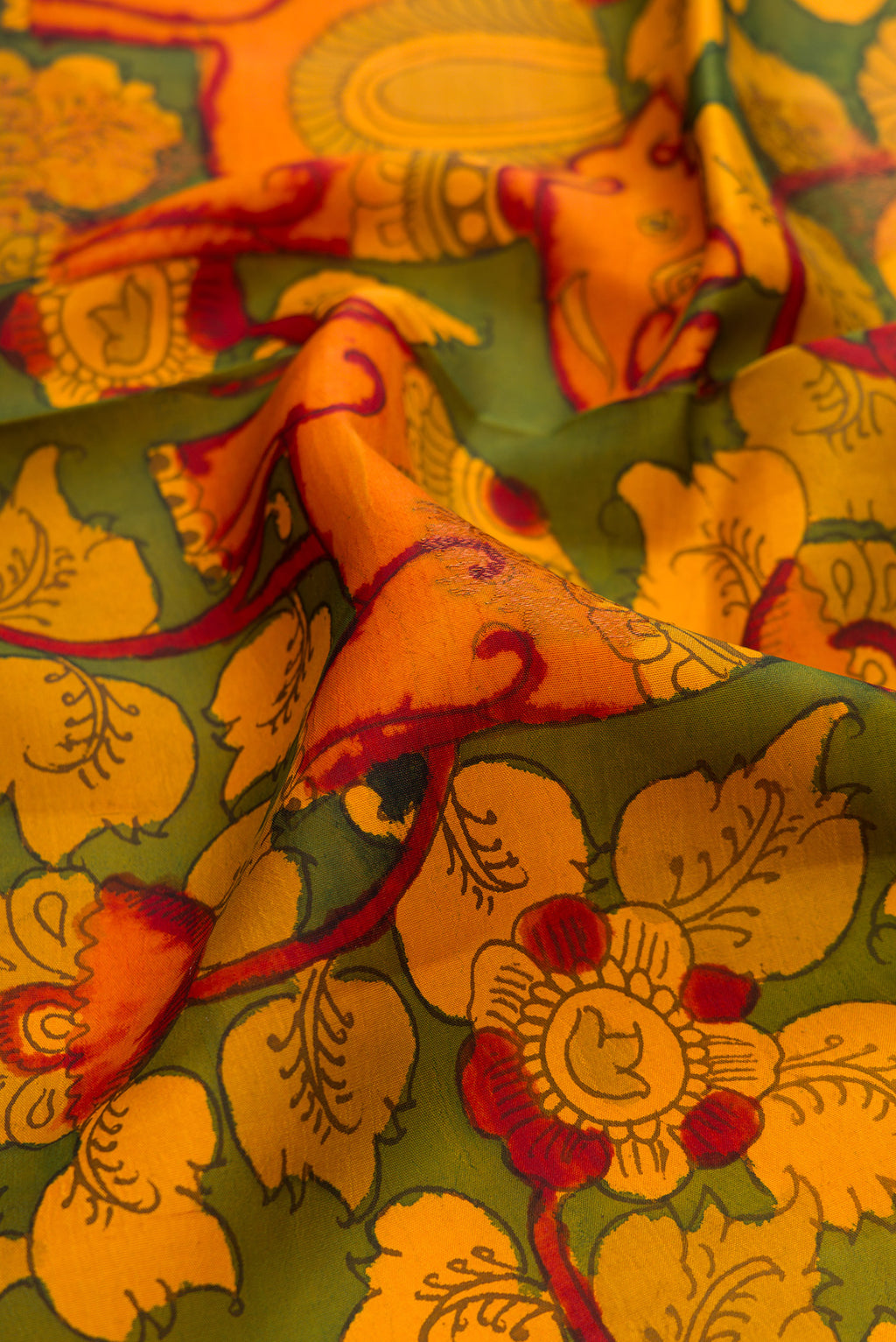 Close up of Green Dual Tone Kanchipuram Silk Saree with kalamkari Print on the body and Zari Border.  displaying folds