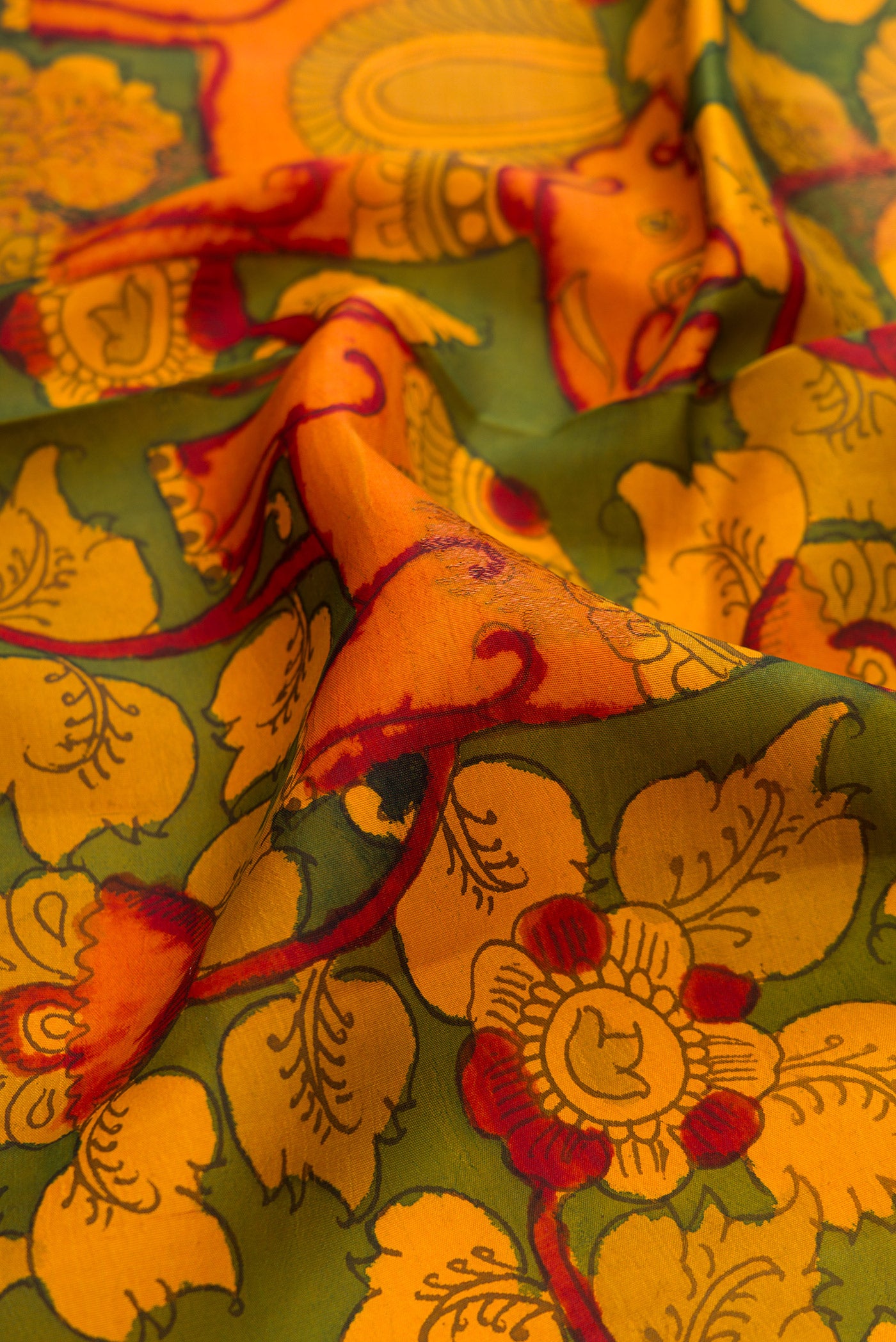 Close up of Green Dual Tone Kanchipuram Silk Saree with kalamkari Print on the body and Zari Border.  displaying folds