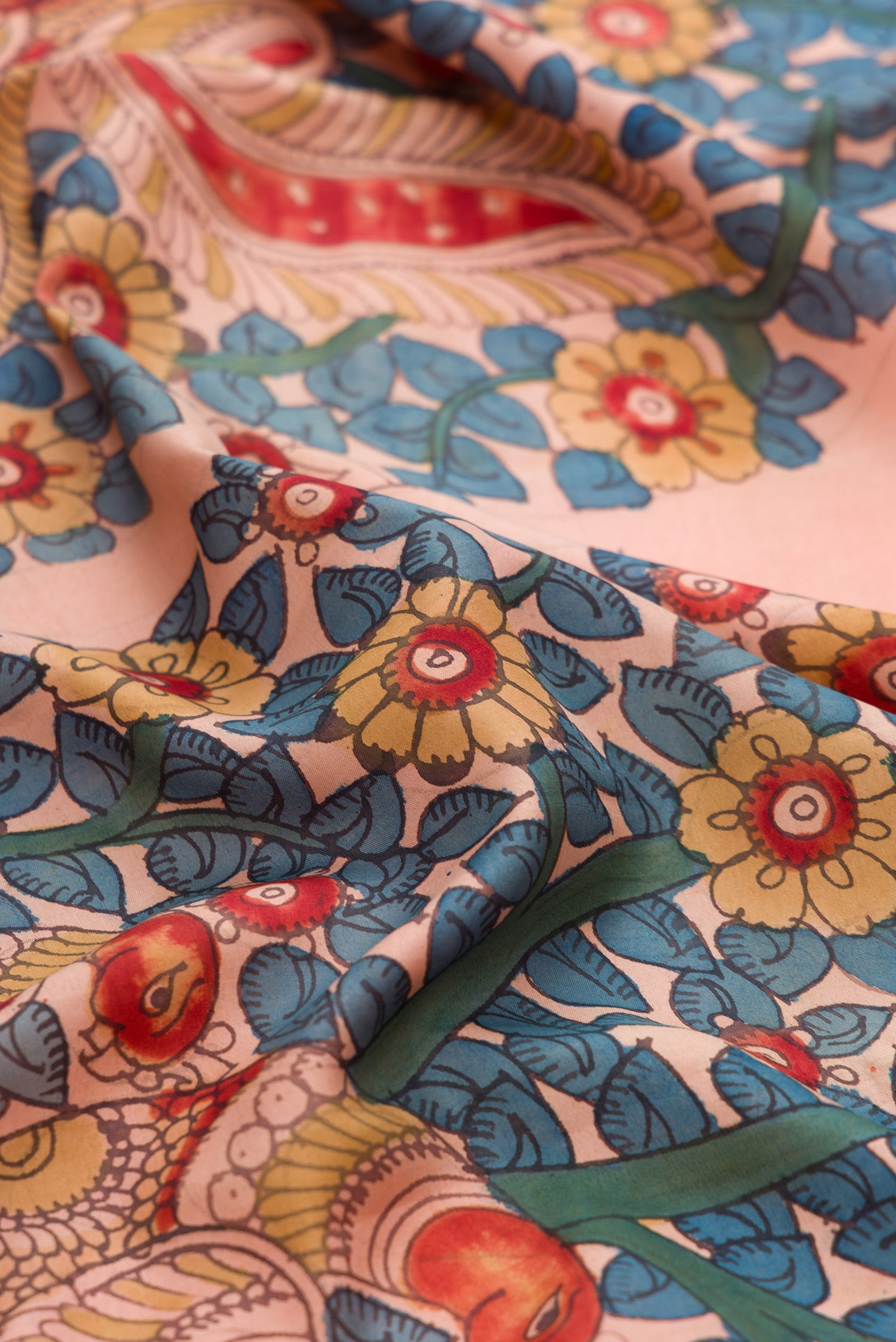 Close up of Golden Peach Dual Tone Kanchipuram Silk Saree with kalamkari Print on the body and Zari Border.  displaying folds