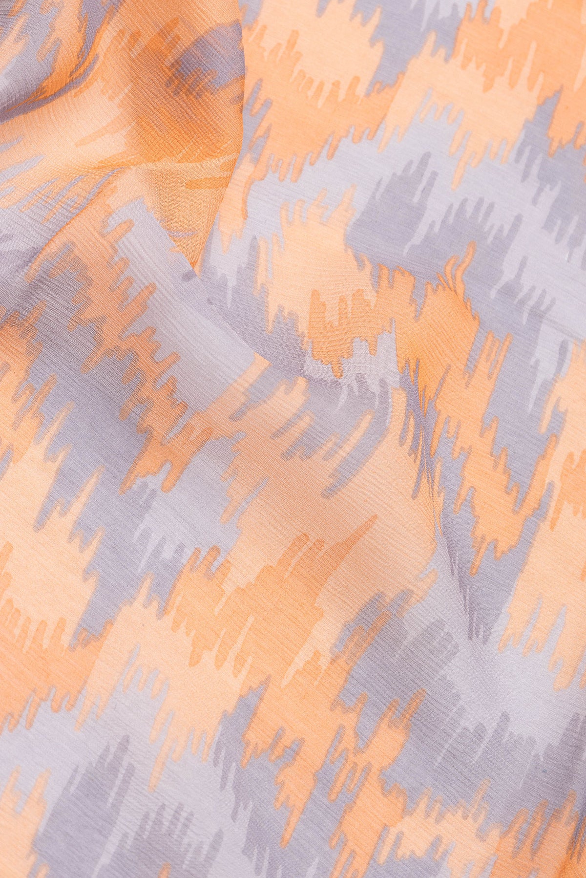 Close up of Orange Dual Tone Mysore Chiffon Saree with Printed design on the body and Zari Border.  displaying folds