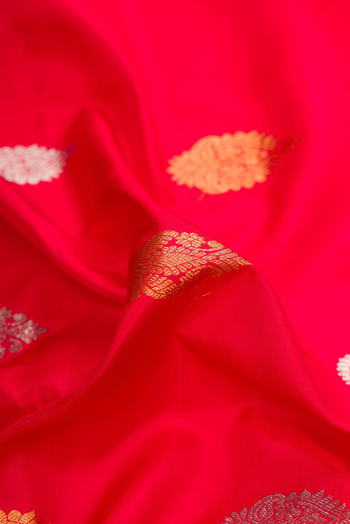 Close up of Red Dual Tone Gadwal Silk Saree with Zari Butta on the body and Zari Border.  displaying folds