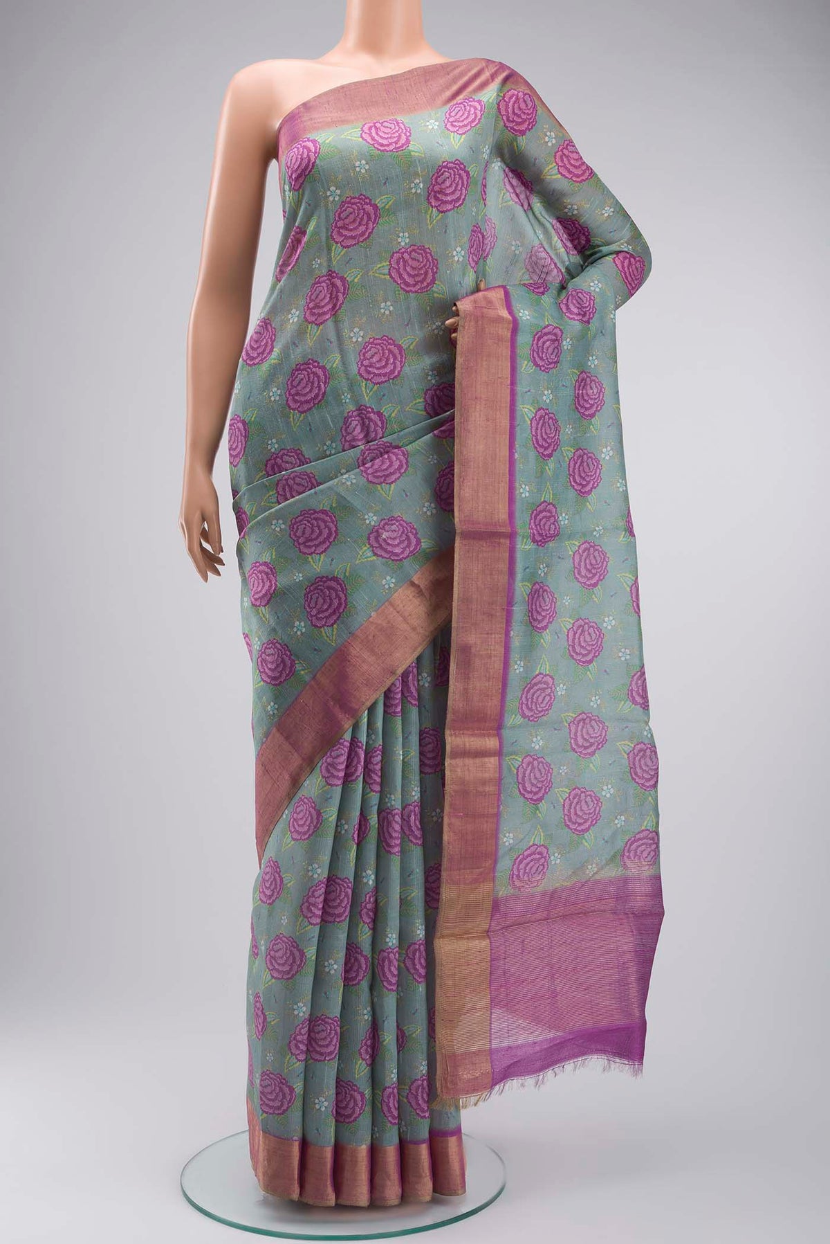 Green Tussar Silk Saree with Printed design on the body and Zari Border displayed on a mannequin