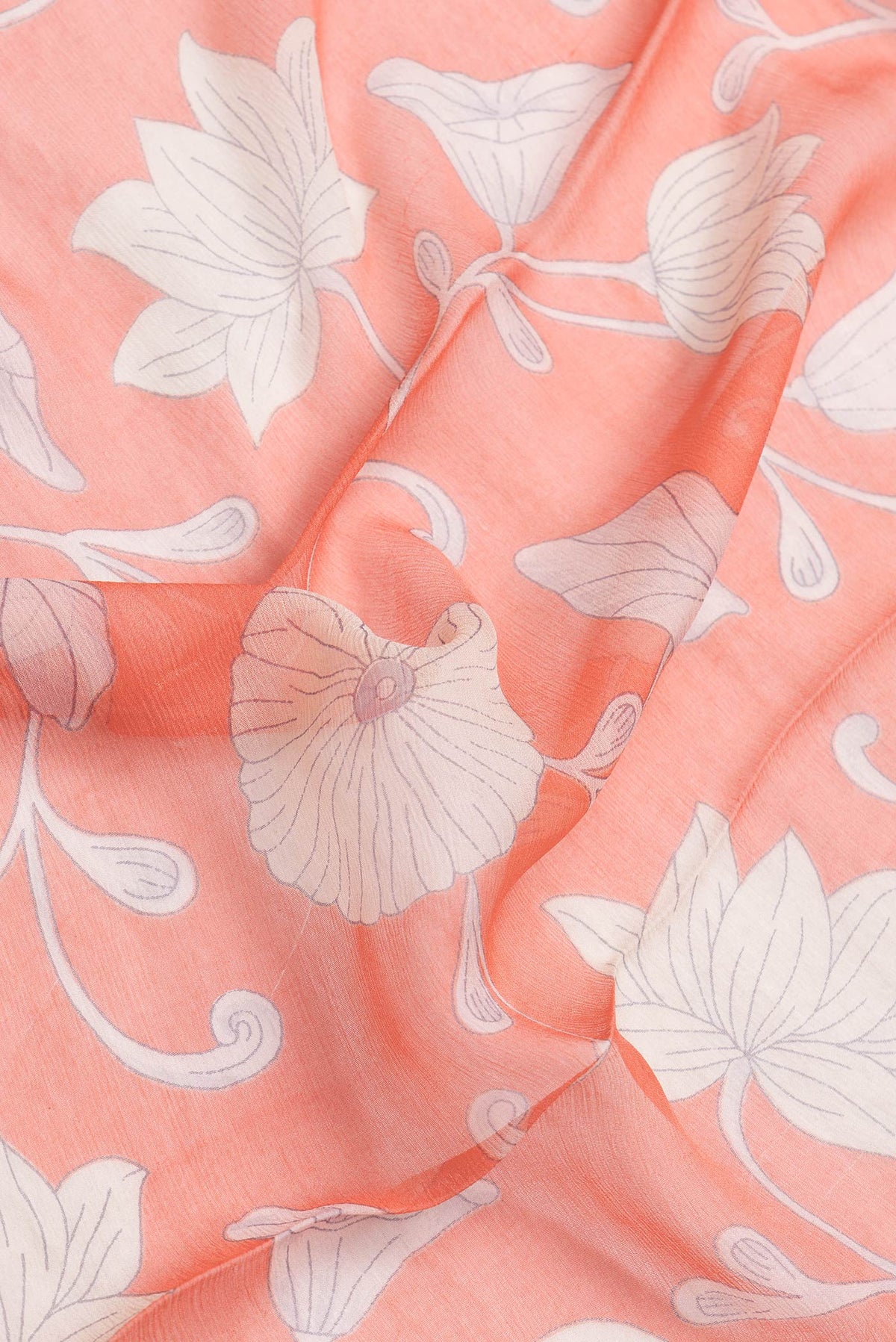Close up of Orange Dual Tone Chiffon Saree with Printed design on the body and Zari Border.  displaying folds