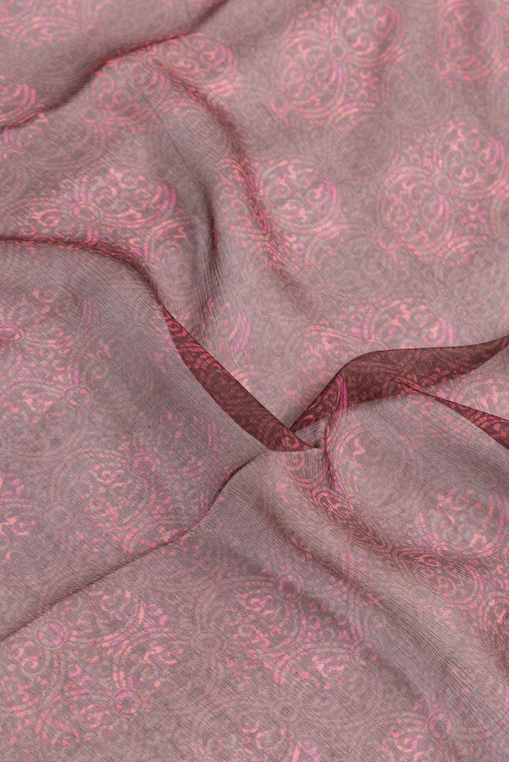 Close up of Brown Dual Tone Chiffon Saree with Printed design on the body and Zari Border.  displaying folds