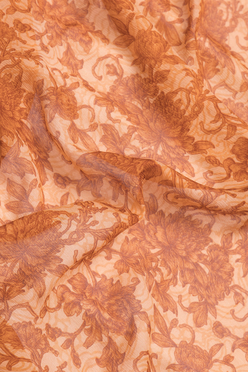 Close up of Golden Peach Dual Tone Chiffon Saree with Printed design on the body and Thread Border.  displaying folds