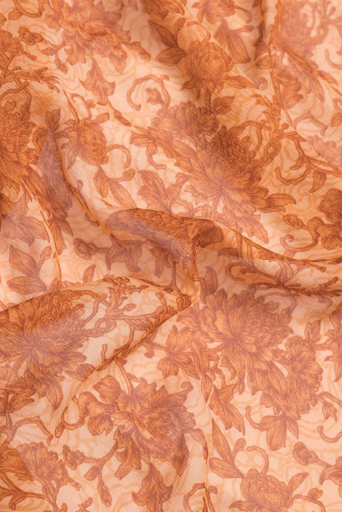 Close up of Golden Peach Dual Tone Chiffon Saree with Printed design on the body and Thread Border.  displaying folds
