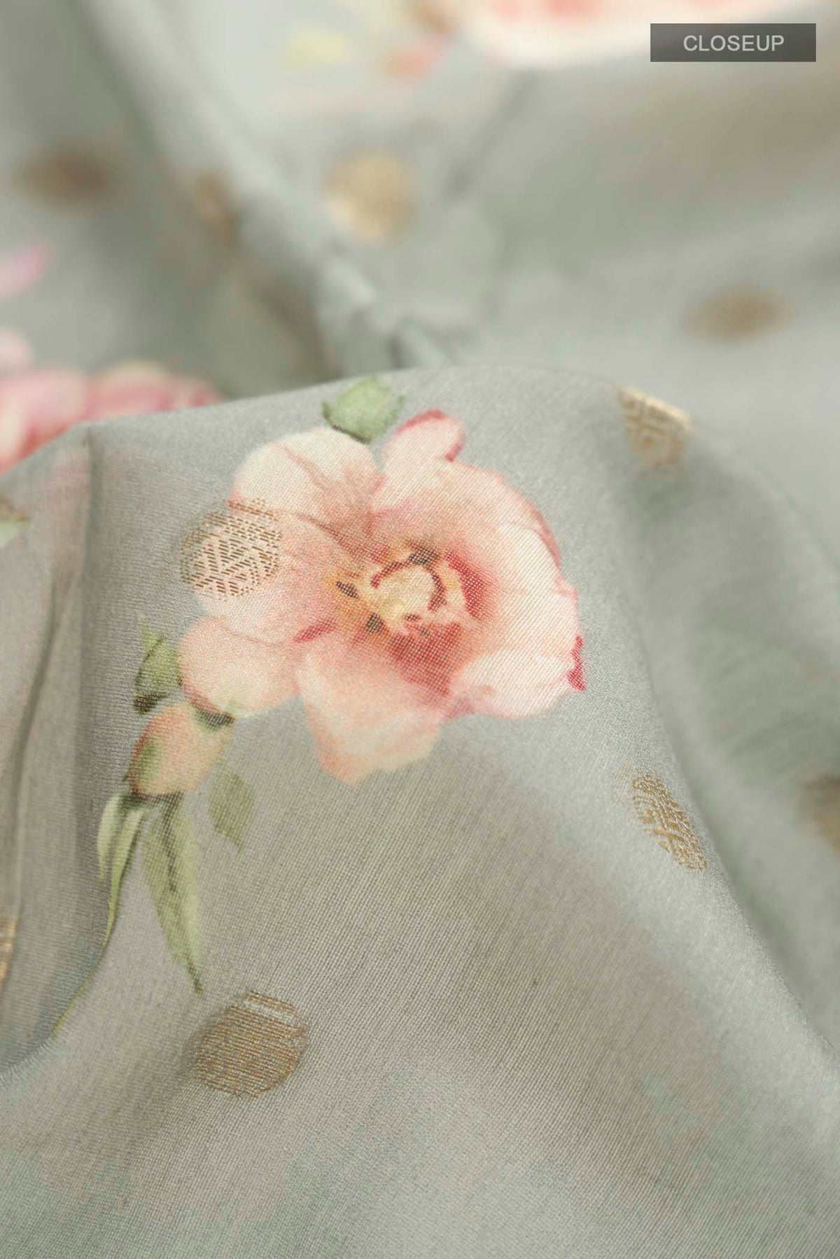 Close up of Sage Green Silk Cotton Saree with Printed design on the body and Zari Border displaying folds