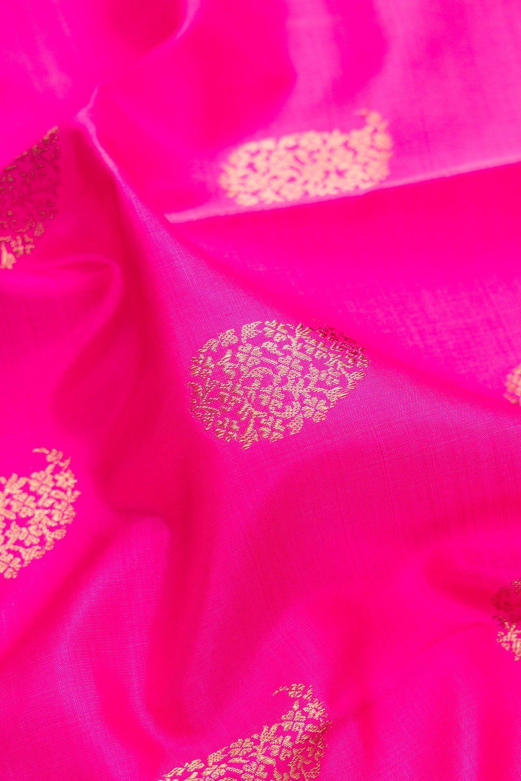 Close up of Pure Silk Pure Zari Pink Kanjivaram Saree with Zari Butta on the body and Zari Border.  displaying folds