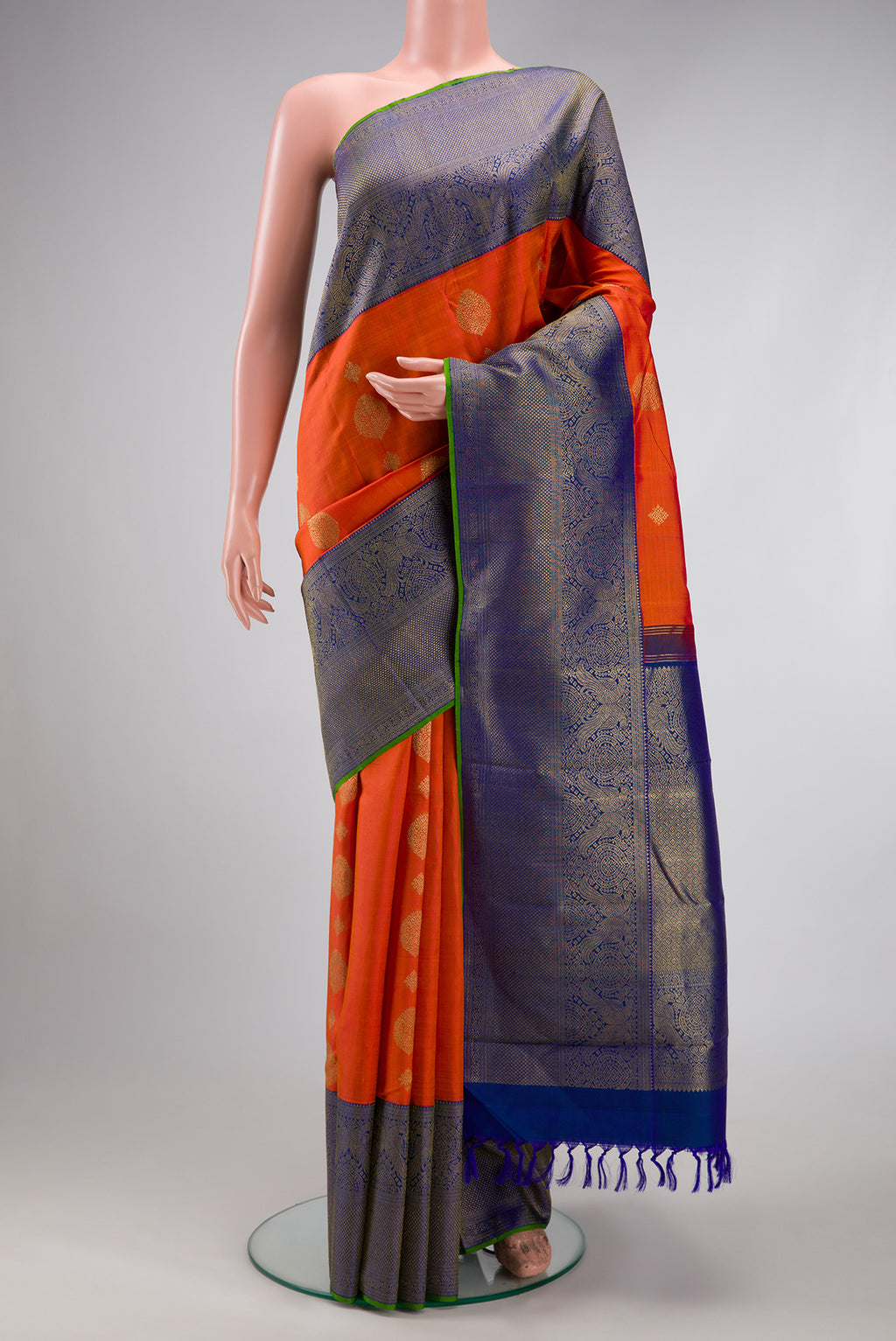 Pure Silk Pure Zari Orange Kanjivaram Saree with Zari Butta on the body and Fancy Border.  displayed on a mannequin