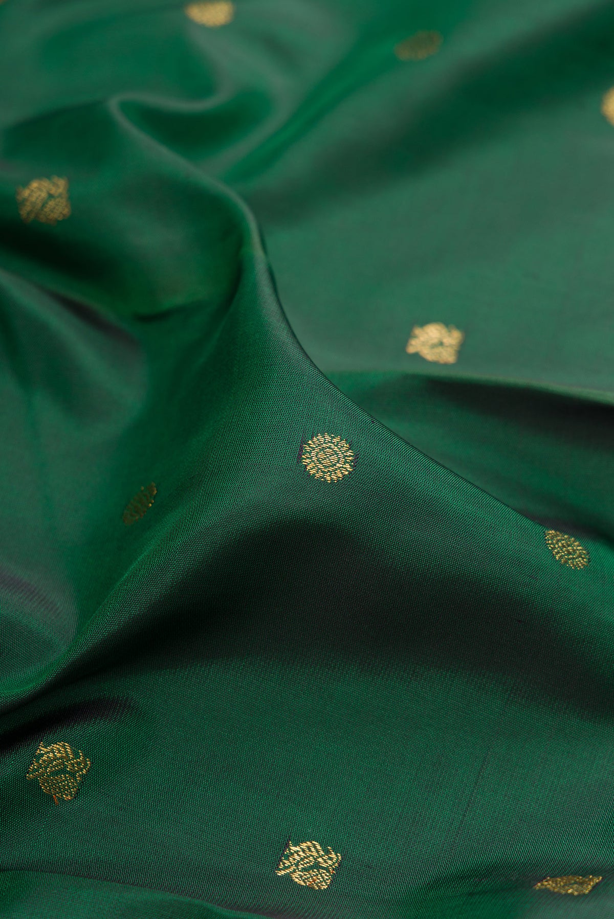 Close up of Pure Silk Pure Zari Bottle Green Kanjivaram Saree with Zari Butta on the body and Zari Border.  displaying folds