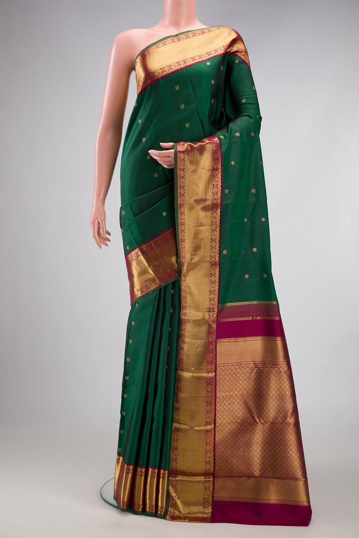 Pure Silk Pure Zari Bottle Green Kanjivaram Saree with Zari Butta on the body and Zari Border.  displayed on a mannequin