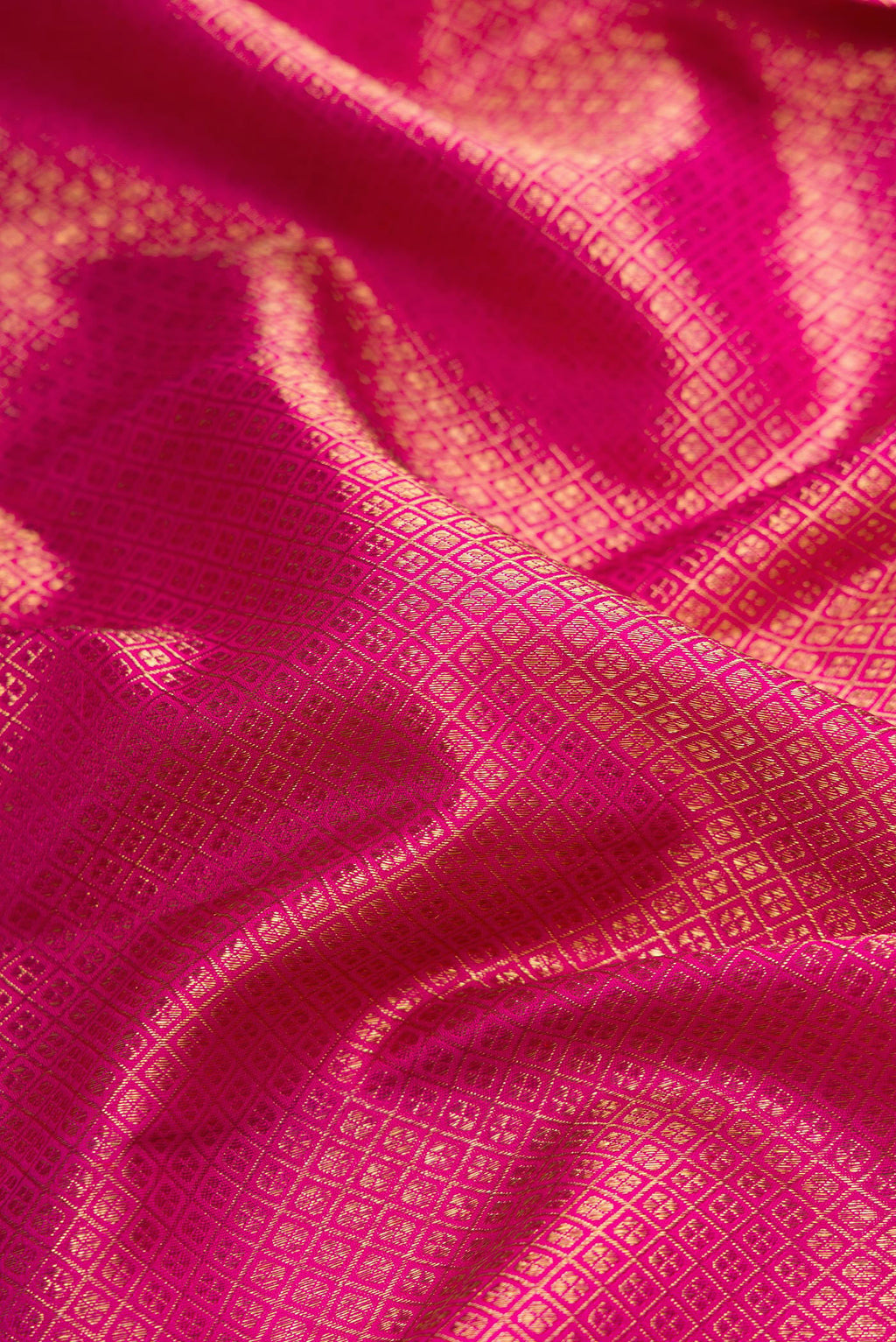Close up of Pure Silk Pure Zari Magenta Dual Tone Kanjivaram Saree with Zari Brocade on the body and Zari Border.  displaying folds