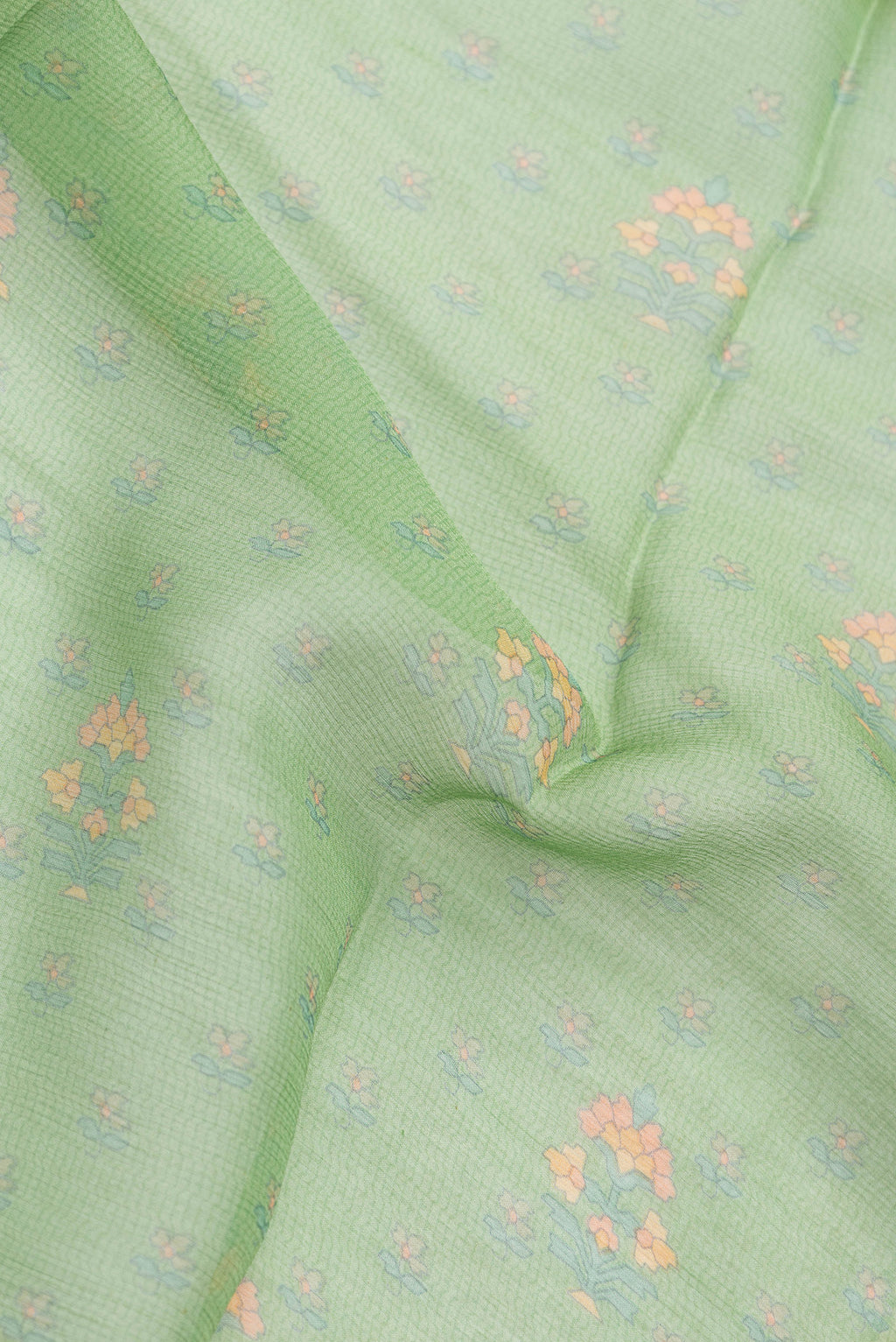 Close up of Pista Green Mysore Chiffon Saree with Printed design on the body and Zari Border.  displaying folds