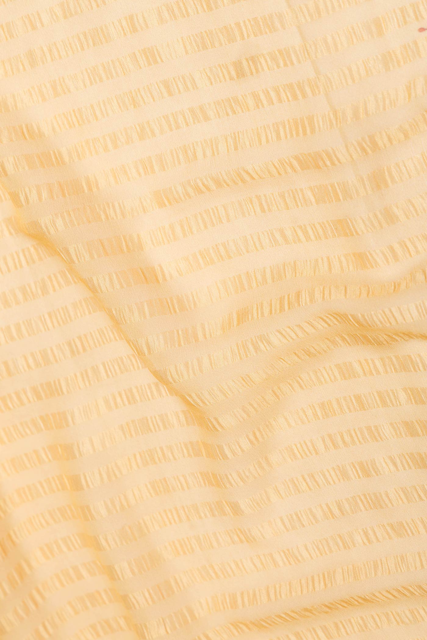 Close up of Yellow Dual Tone Mysore Chiffon Saree with Printed design on the body and Zari Border displaying folds