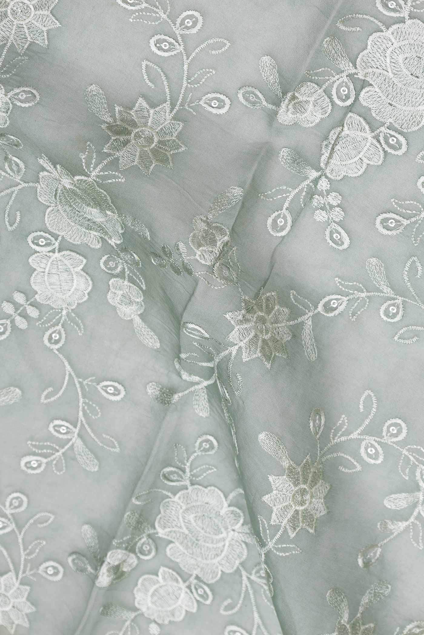 Close up of Light Green Dual Tone Organza Silk Saree with Zari Brocade on the body and Zari Border.  displaying folds