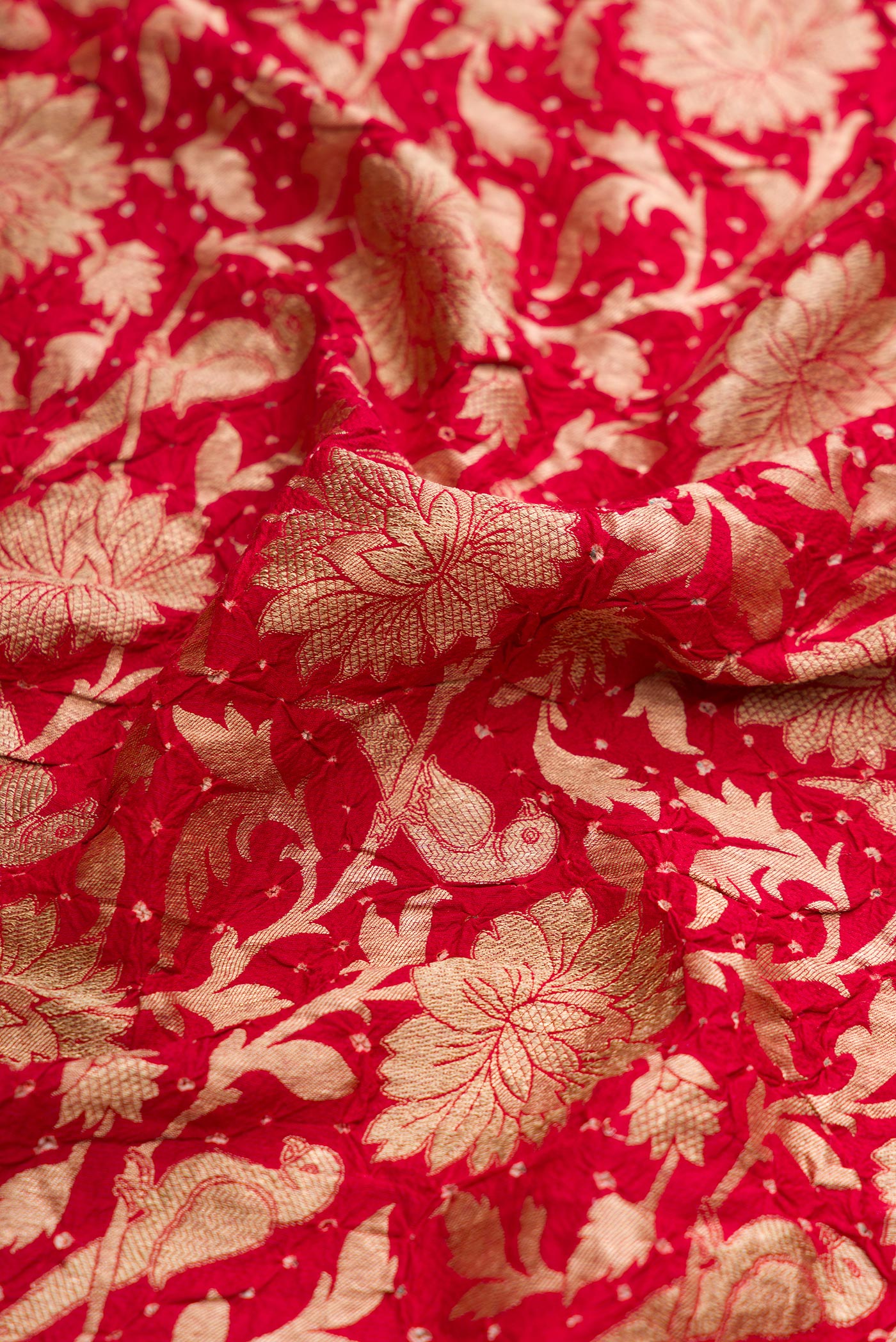 Close up of Red Dual Tone Bandhani Silk Saree with Bandhani Print on the body and Without Border.  displaying folds