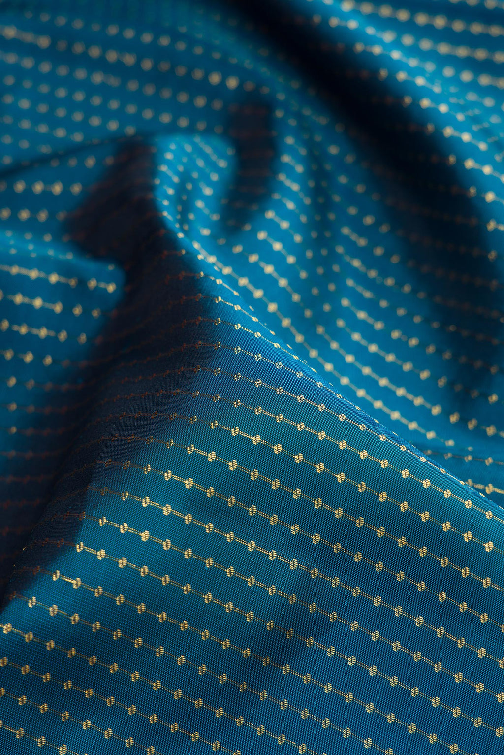Close up of Peacock Blue Kanjivaram Silk Saree with Zari Butta on the body and Without Border.  displaying folds
