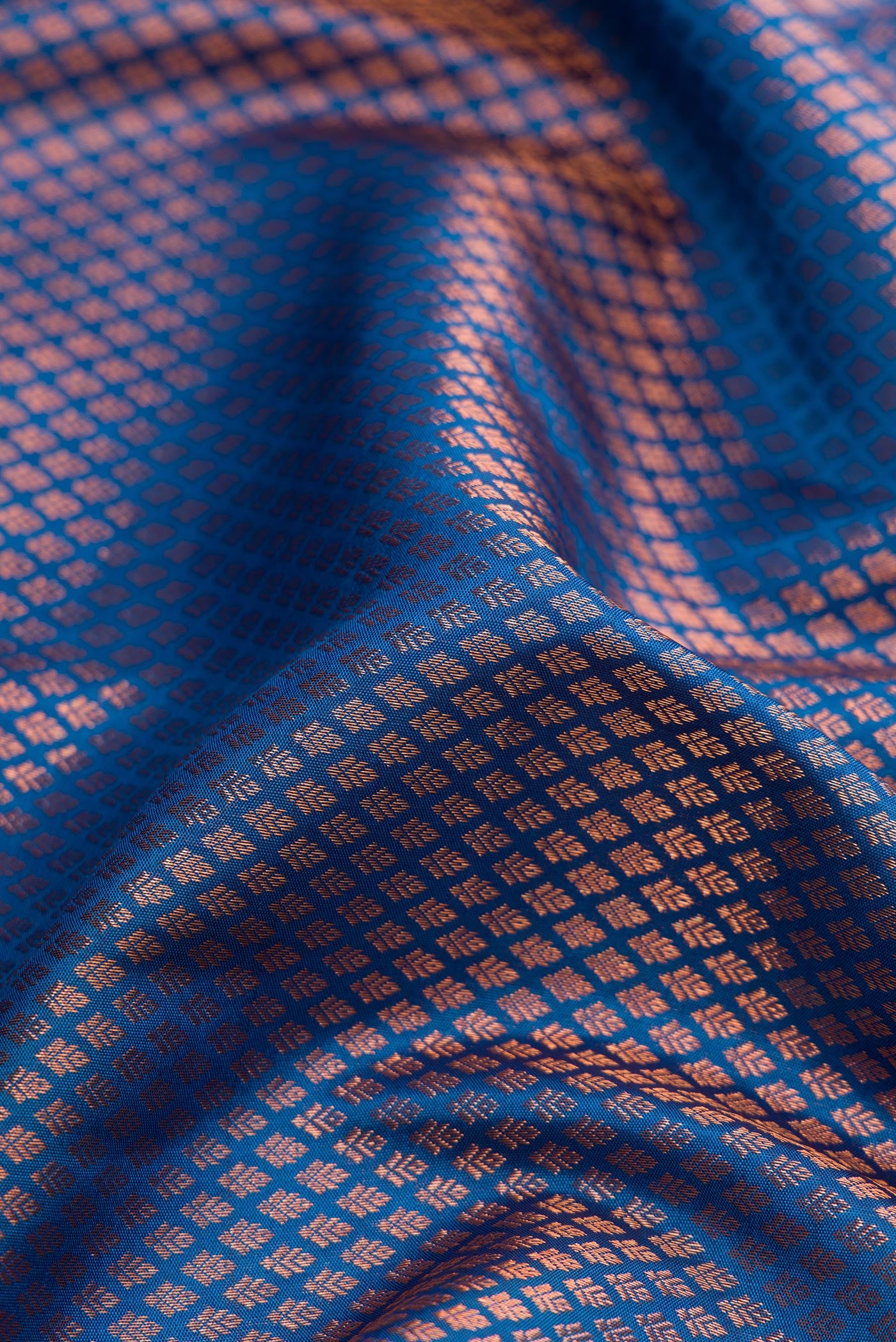 Close up of Peacock Blue Dual Tone Kanchipuram Silk Saree with Zari Brocade on the body and Fancy Border.  displaying folds